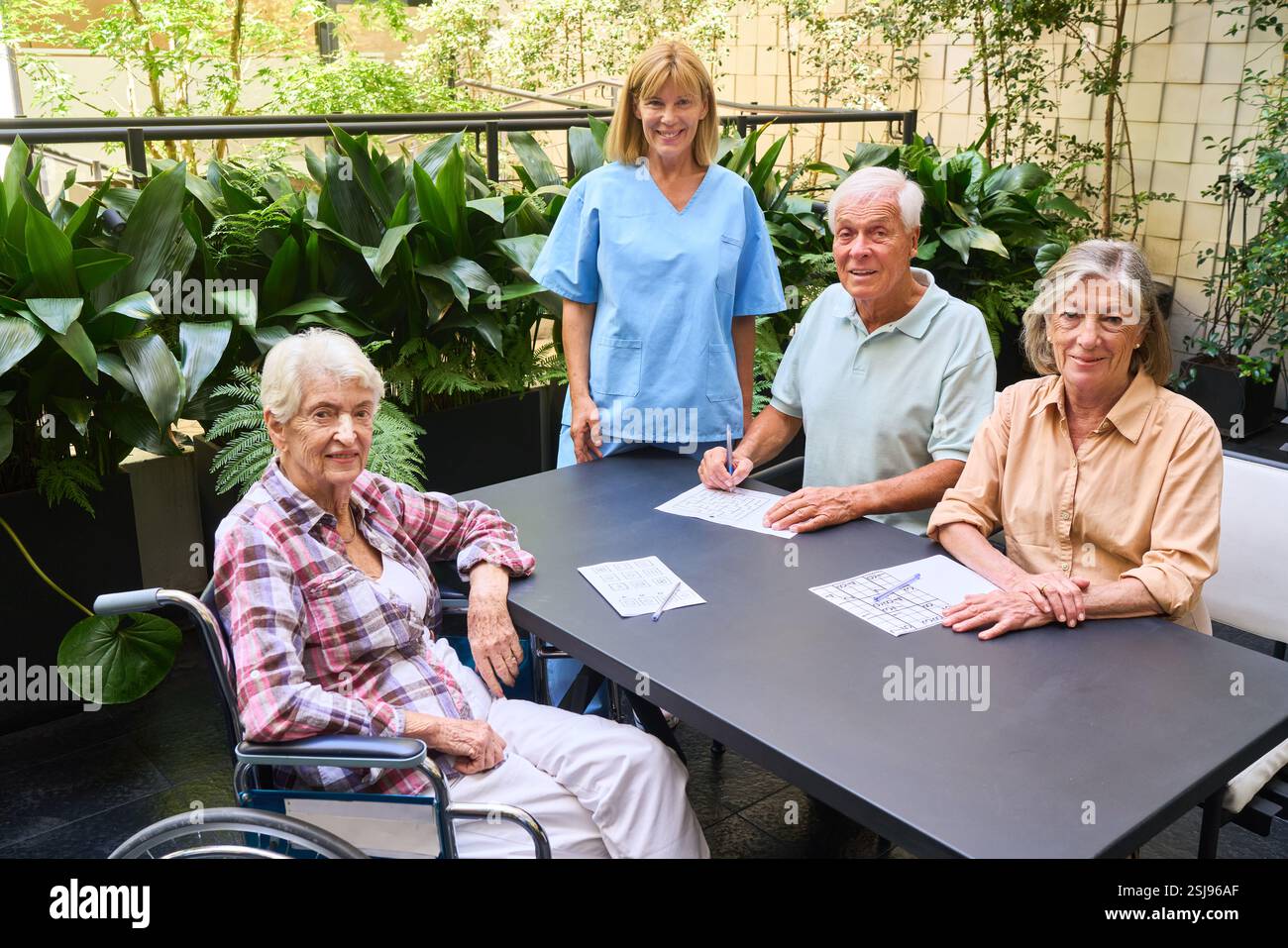 I residenti anziani partecipano ad attività ricreative e terapeutiche con l'assistenza del personale in un ambiente sereno. Questo ritrae la comunità senior Foto Stock