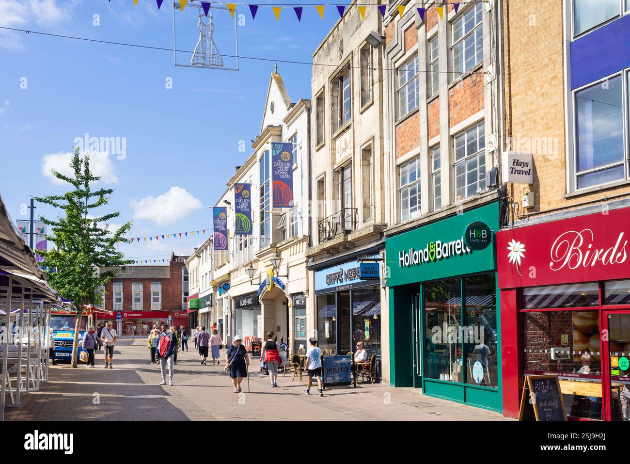 Persone che fanno shopping nei negozi della Market Place Loughborough Leicestershire East Midlands Inghilterra Regno Unito Europa Foto Stock