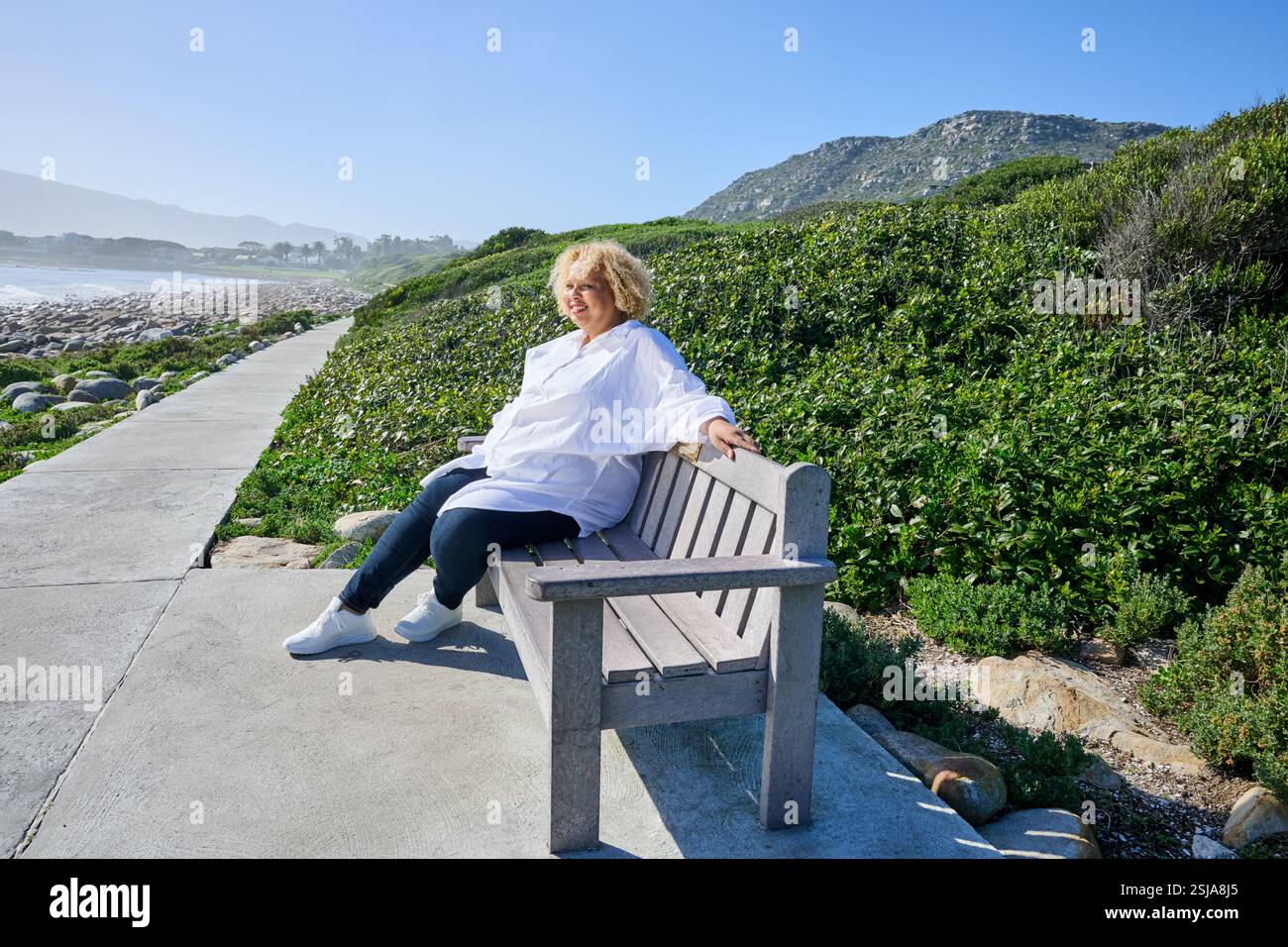 Persona seduta sulla panchina Foto Stock