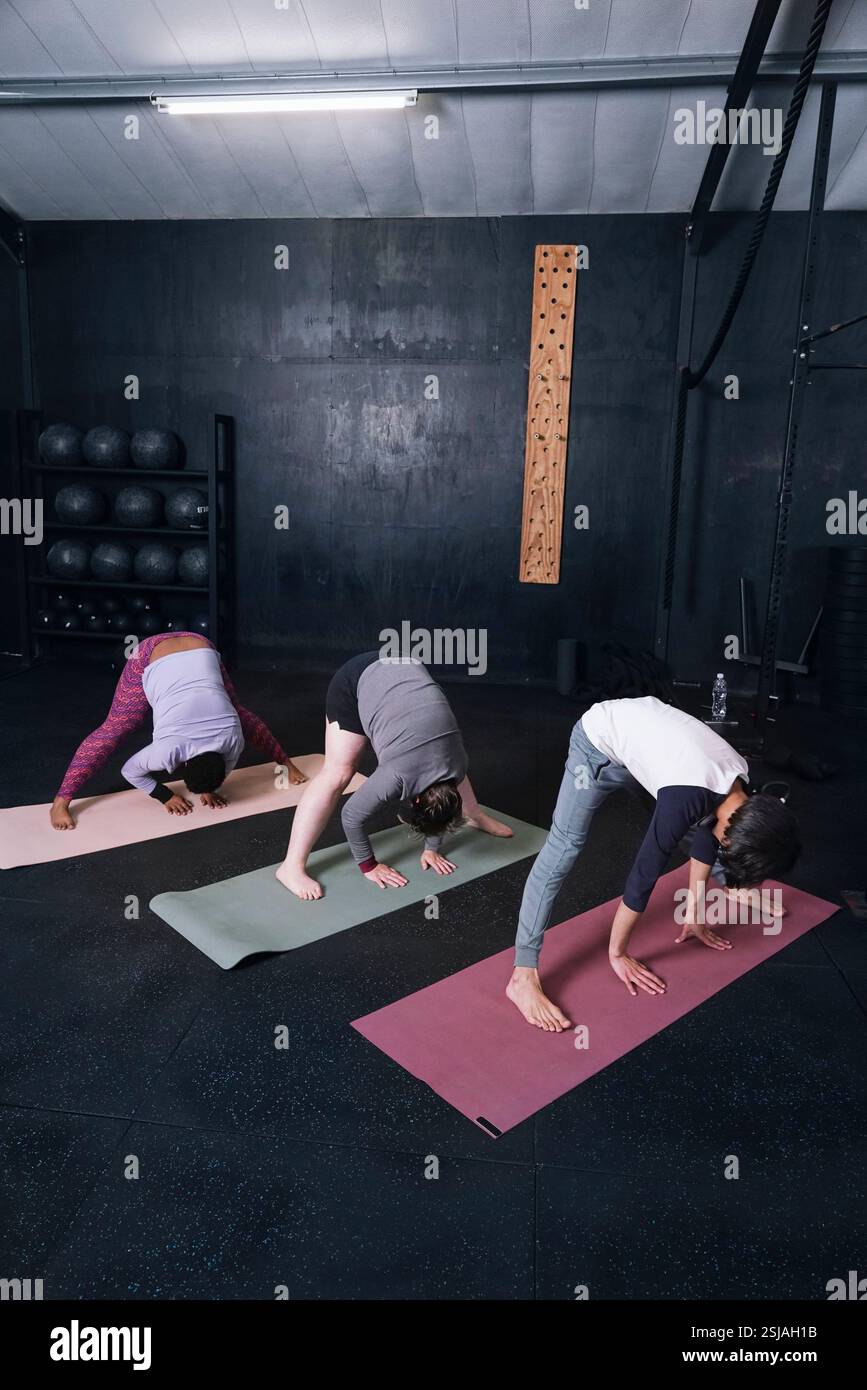 Persone che praticano yoga in palestra Foto Stock
