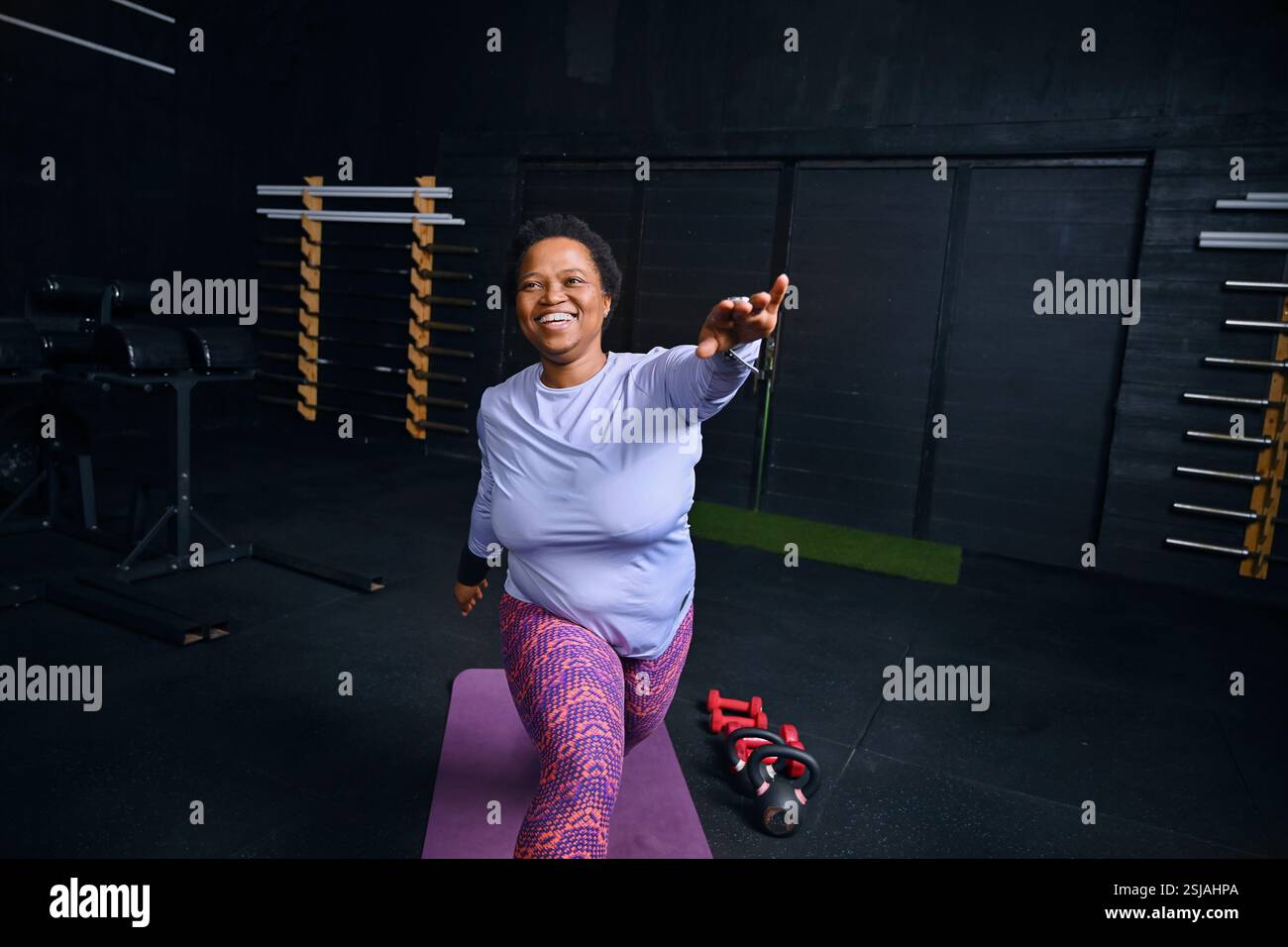 Persona che si allena sul tappetino yoga in palestra Foto Stock