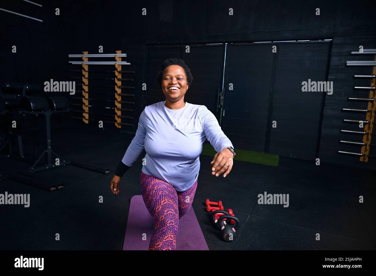 Persona che si allena sul tappetino yoga in palestra Foto Stock