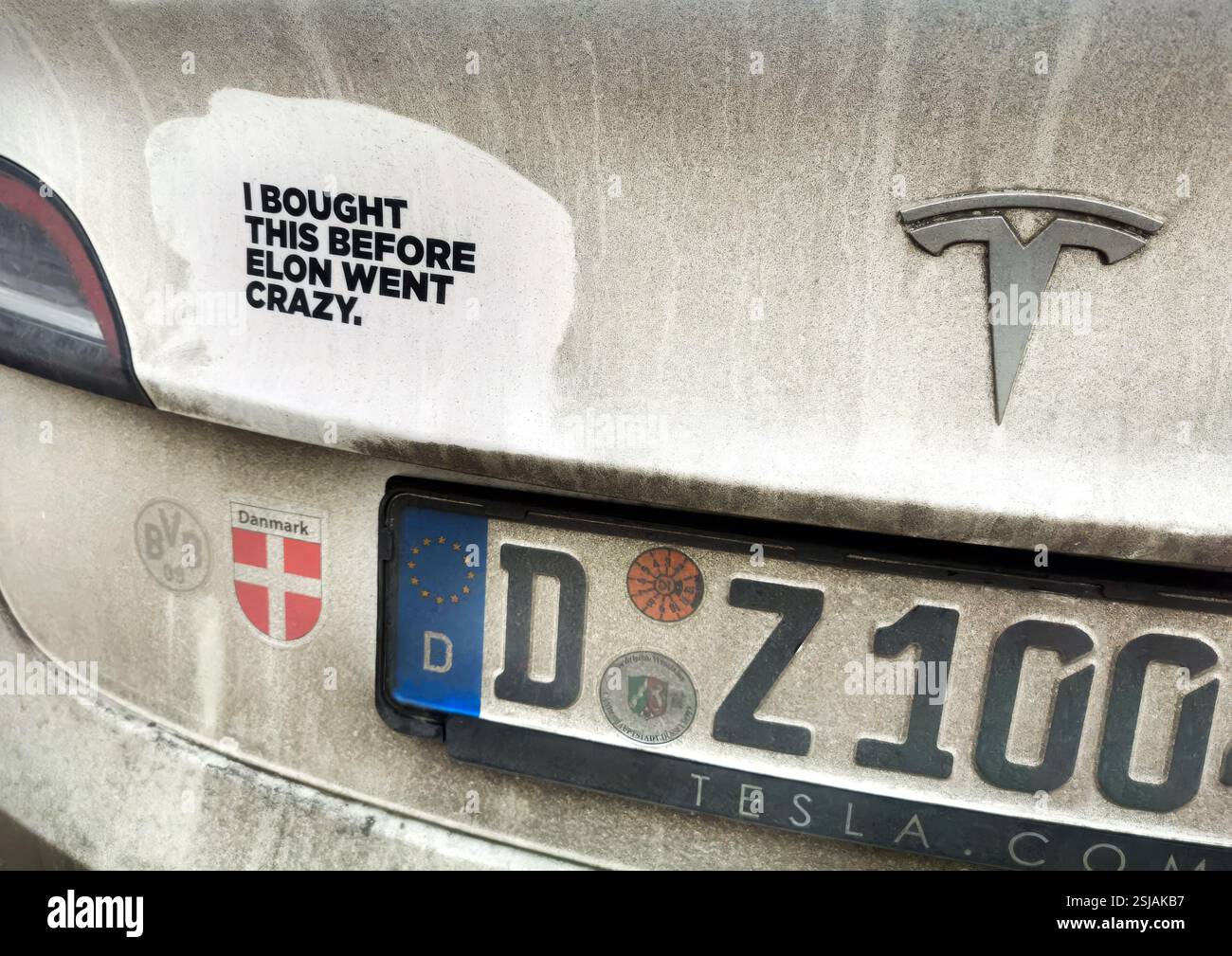 L'adesivo su un'auto TESLA sporca con targa tedesca legge i BOUGT QUESTO PRIMA CHE ELON IMPAZZISSE. Foto Stock