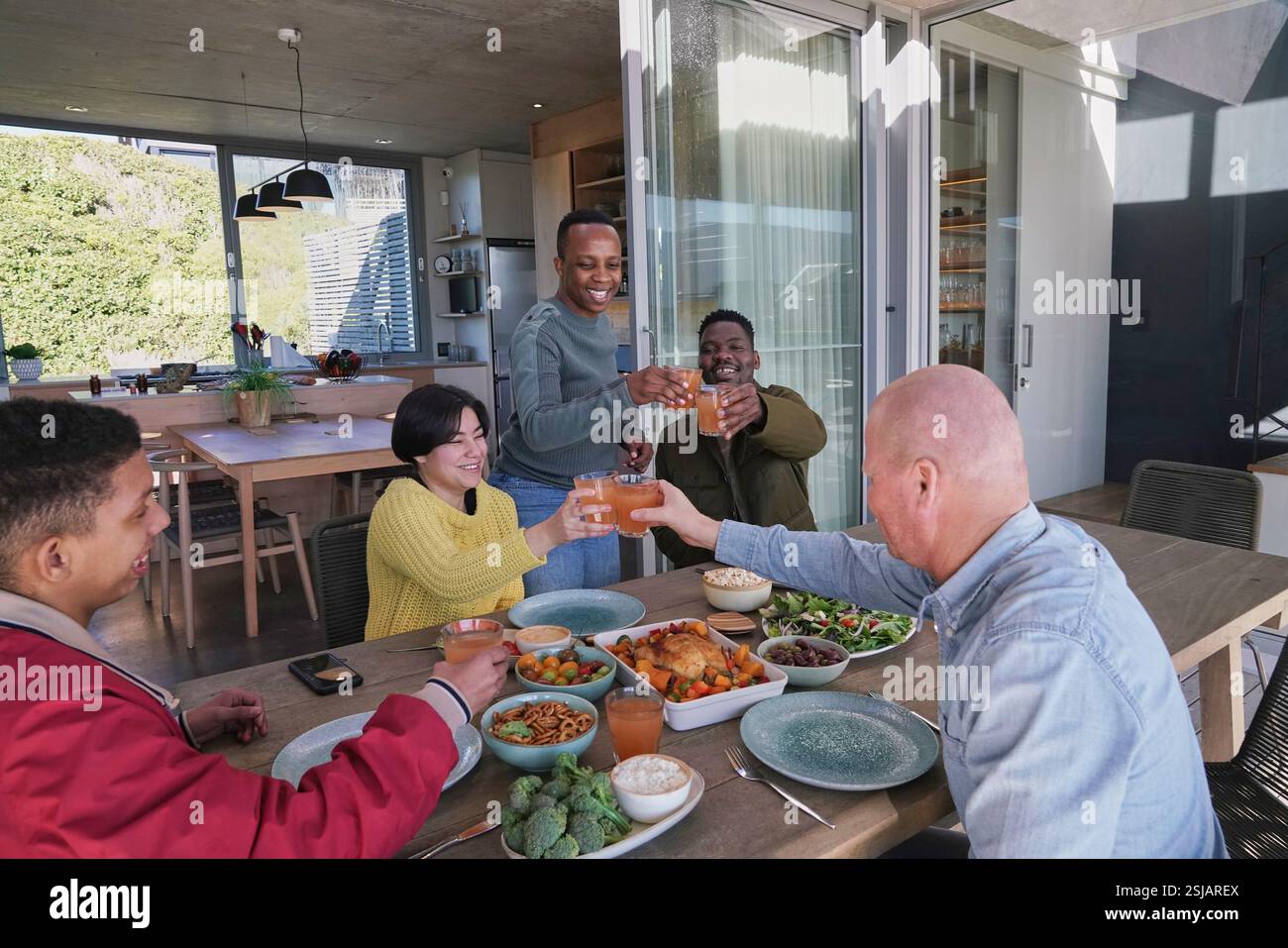 Amici sorridenti che brindano sul patio Foto Stock