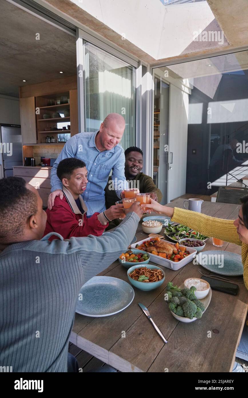 Amici sorridenti che brindano sul patio Foto Stock