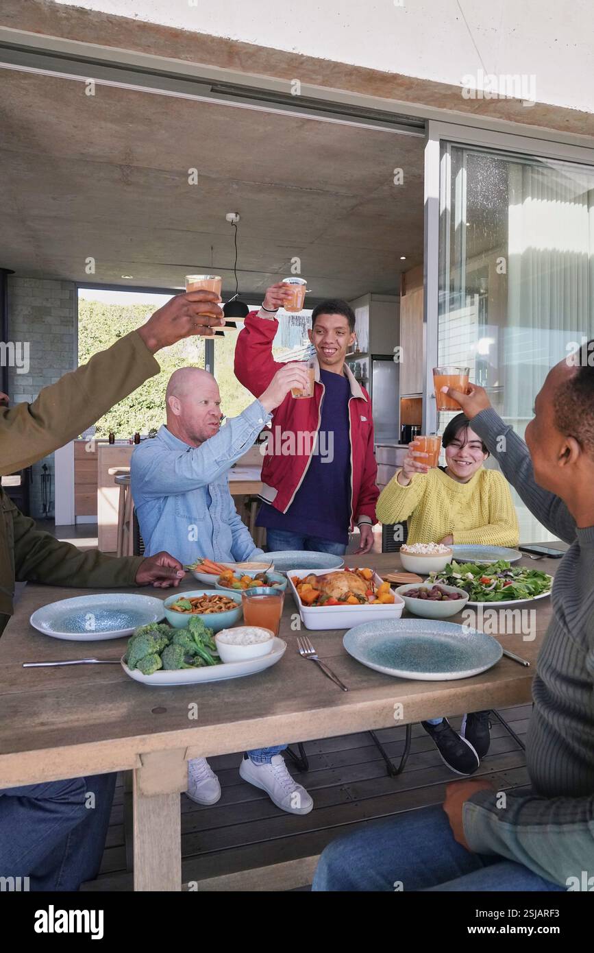 Amici sorridenti che brindano sul patio Foto Stock