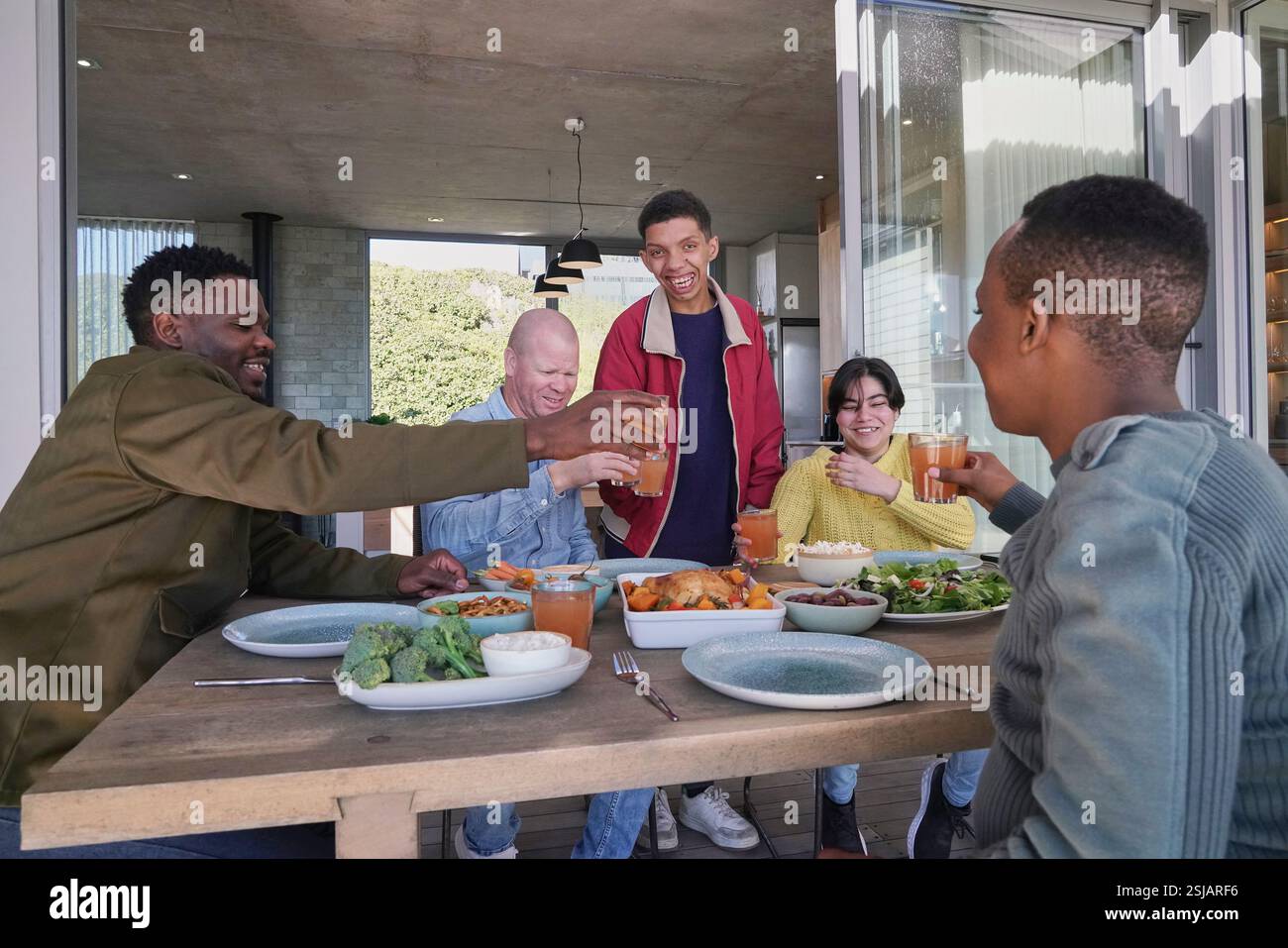Amici sorridenti che brindano sul patio Foto Stock
