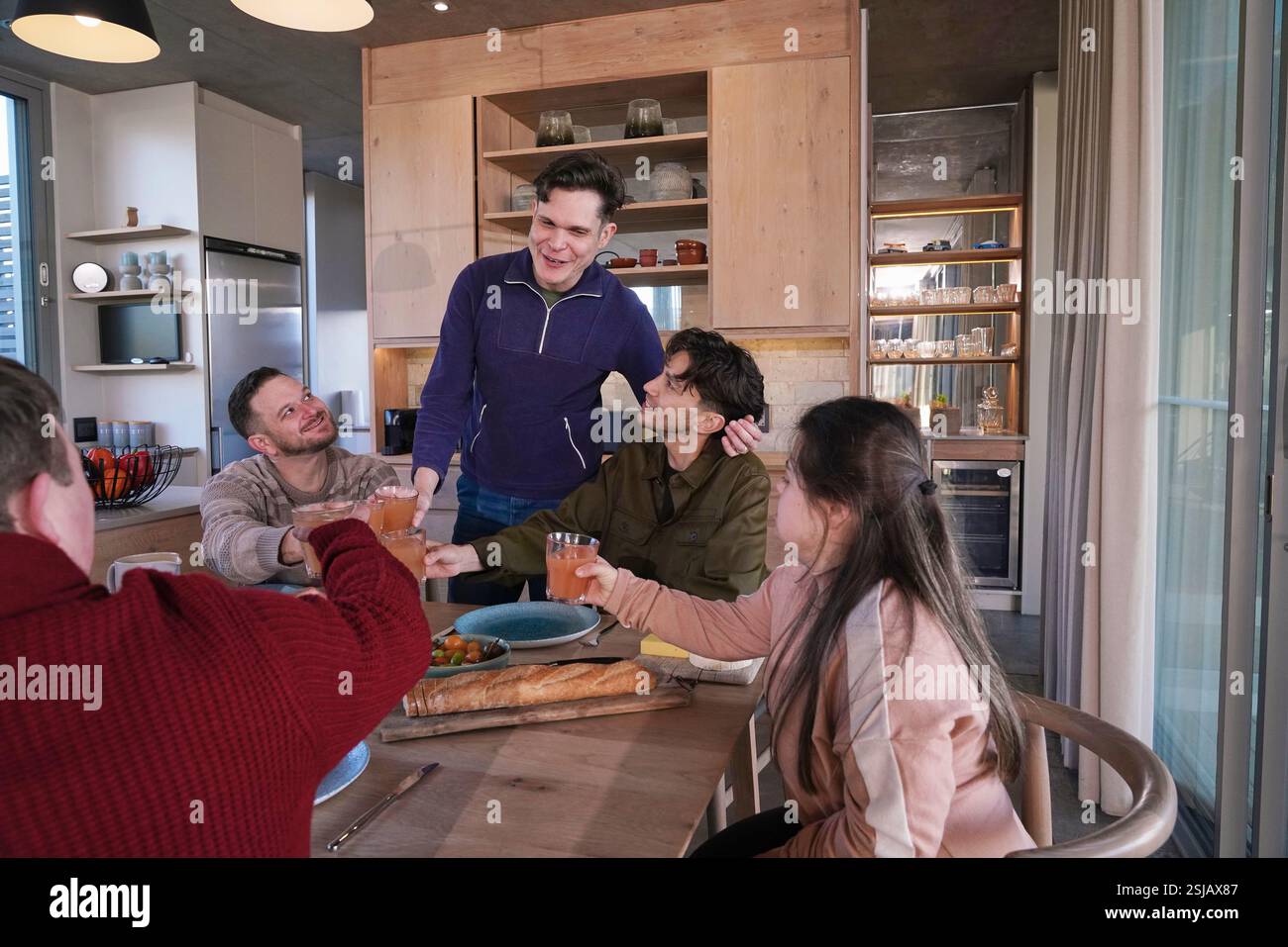 Gli amici la tostatura in tavola di cena Foto Stock
