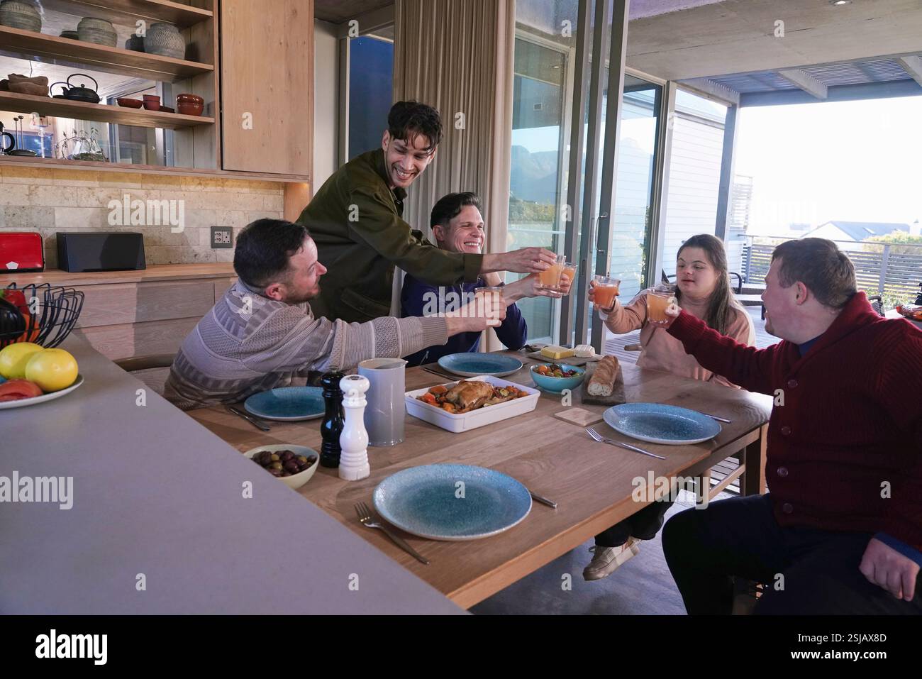 Gli amici la tostatura in tavola di cena Foto Stock