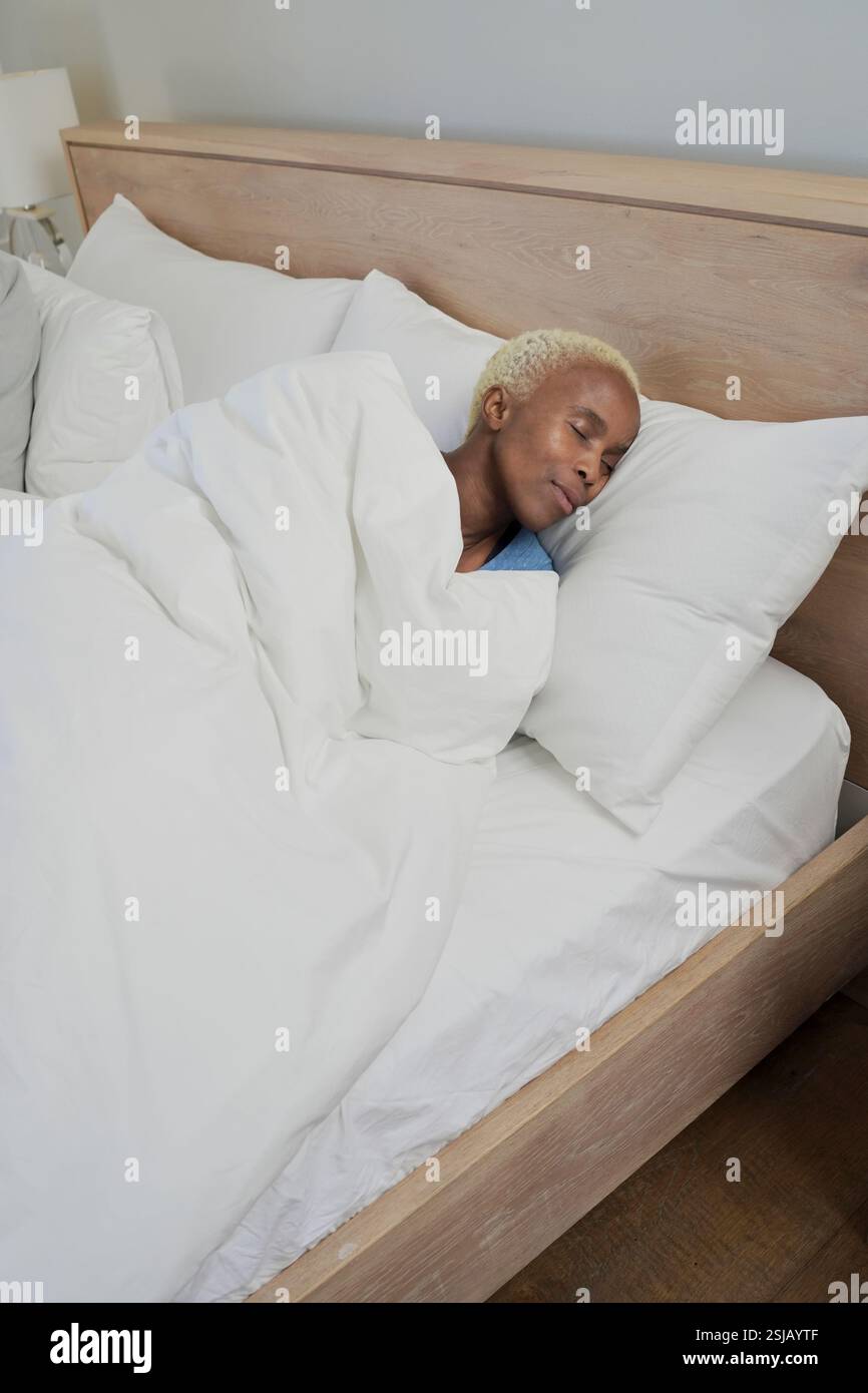 Donna che dorme nel letto Foto Stock