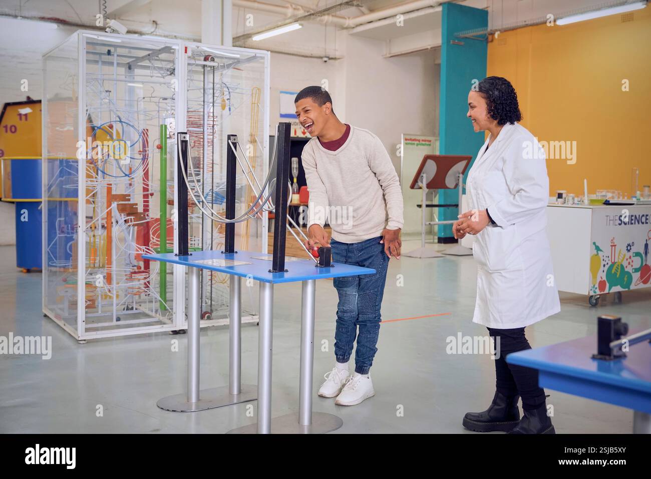 Adolescente che fa esperimenti con l'istruttore Foto Stock