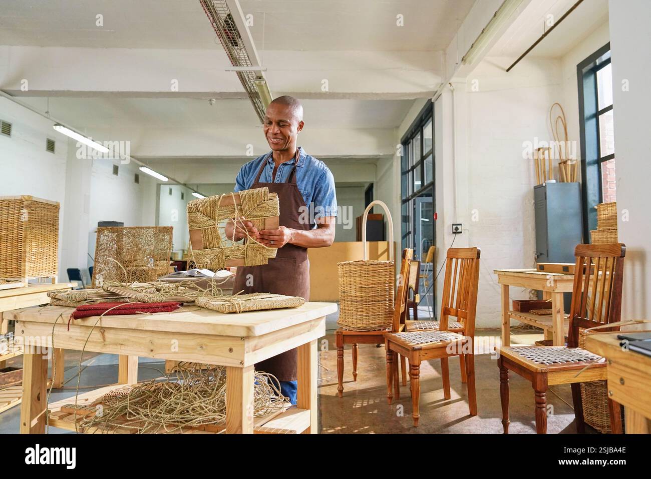 Artigiani che realizzano mobili tessuti in officina Foto Stock