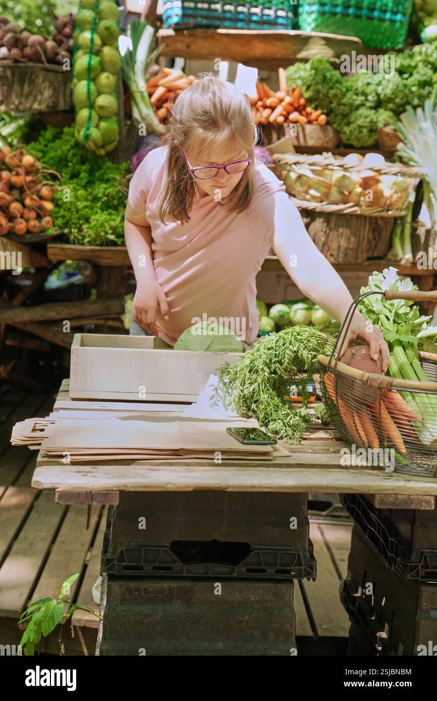Donna disabile che lavora al mercato agricolo Foto Stock