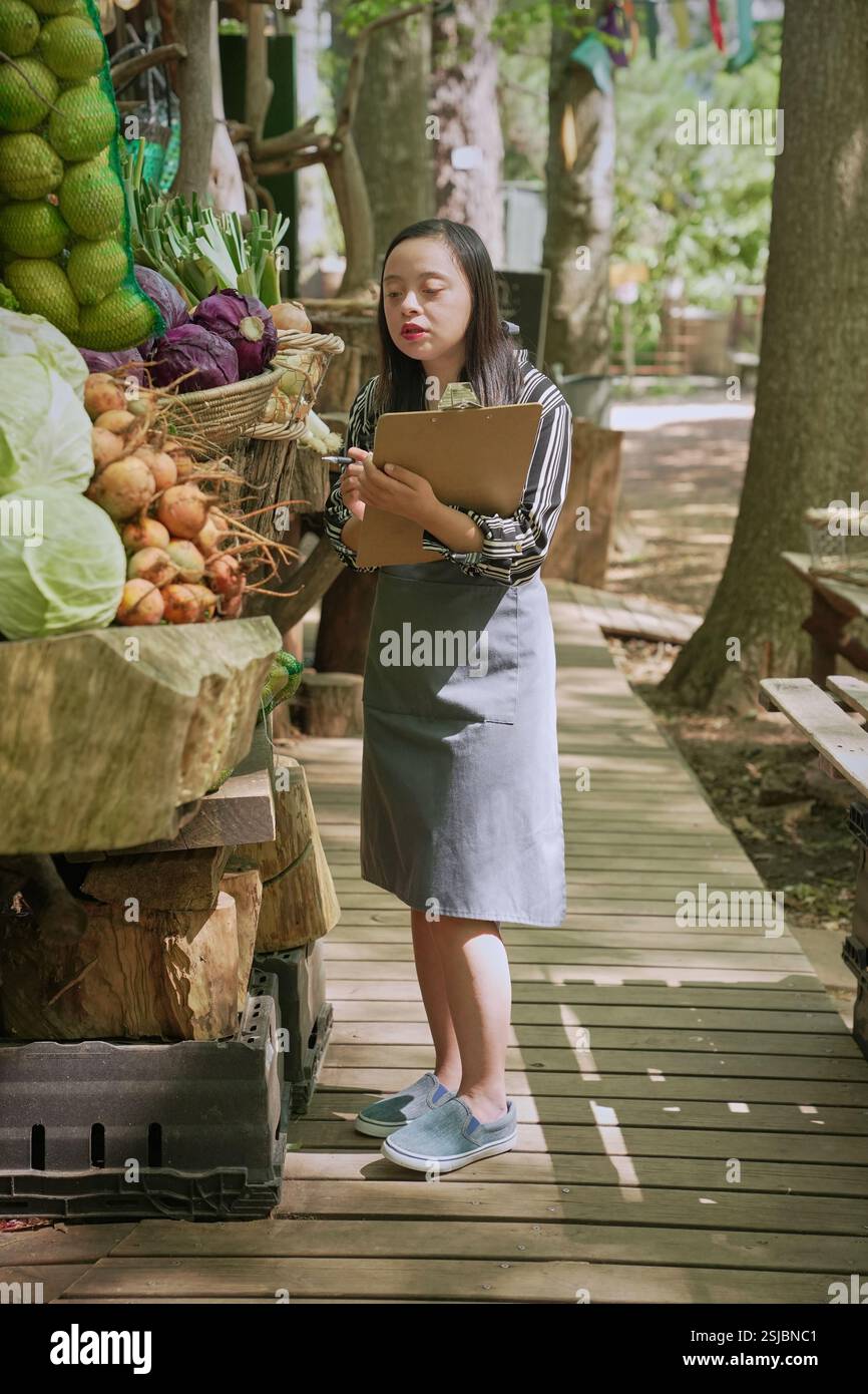 Donna disabile che lavora al mercato agricolo Foto Stock