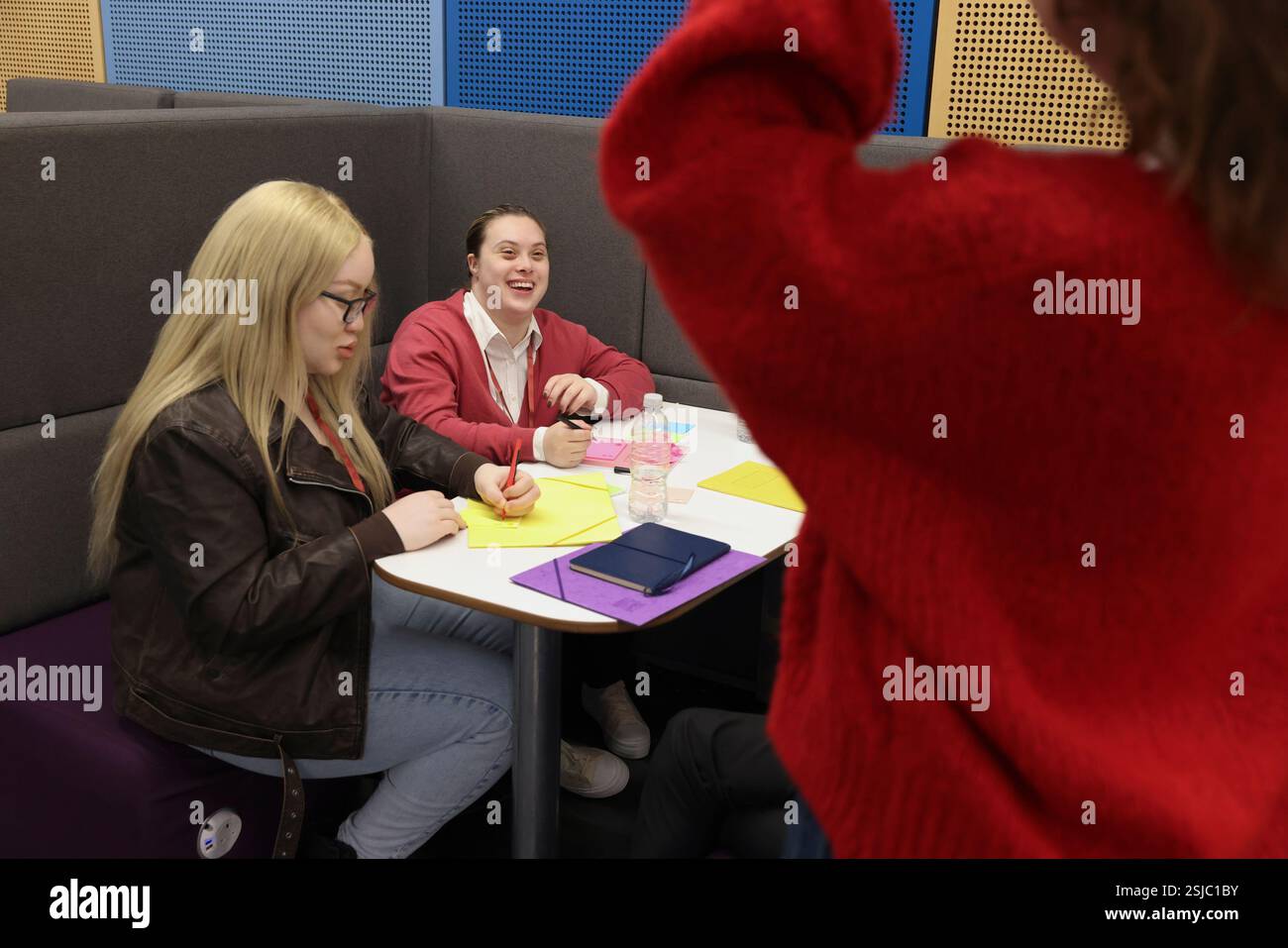 Persone disabili che scrivono al tavolo Foto Stock