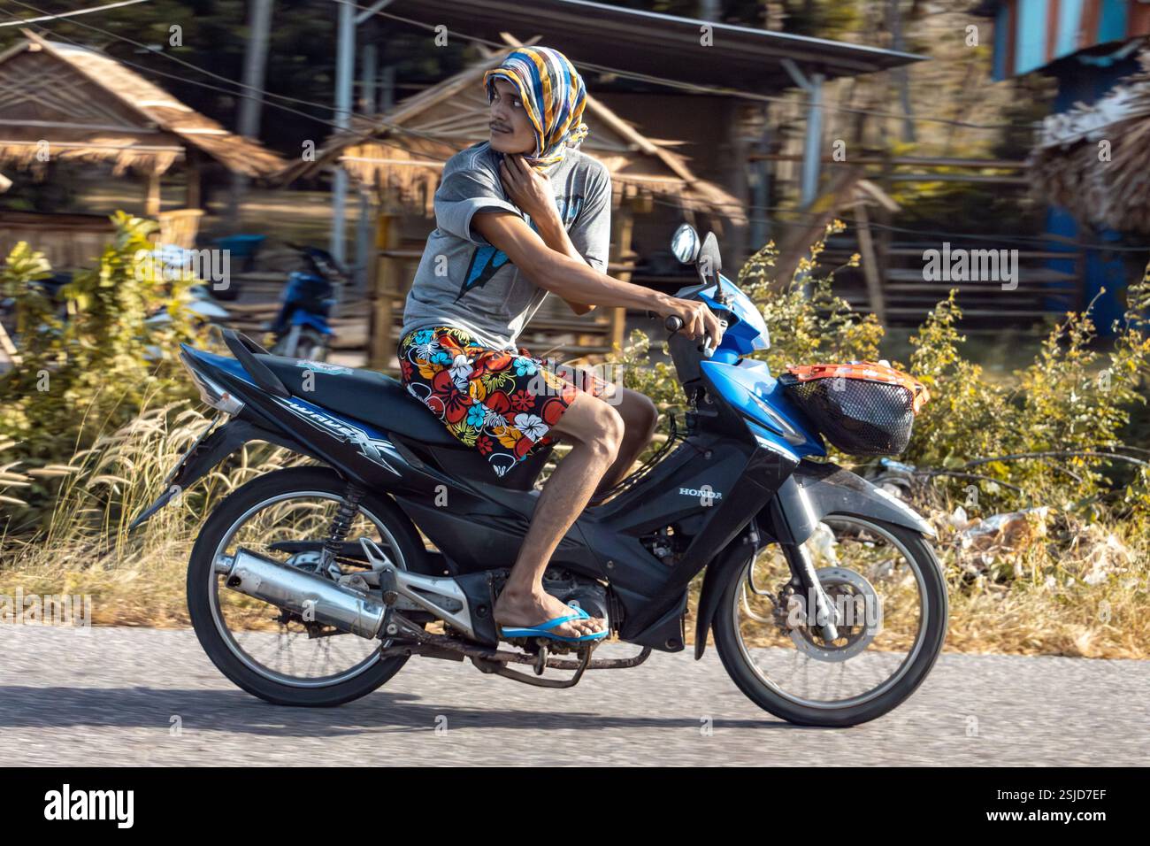 YALA, THAILANDIA, Mar 02 2024, Un uomo guida una moto e guarda indietro Foto Stock