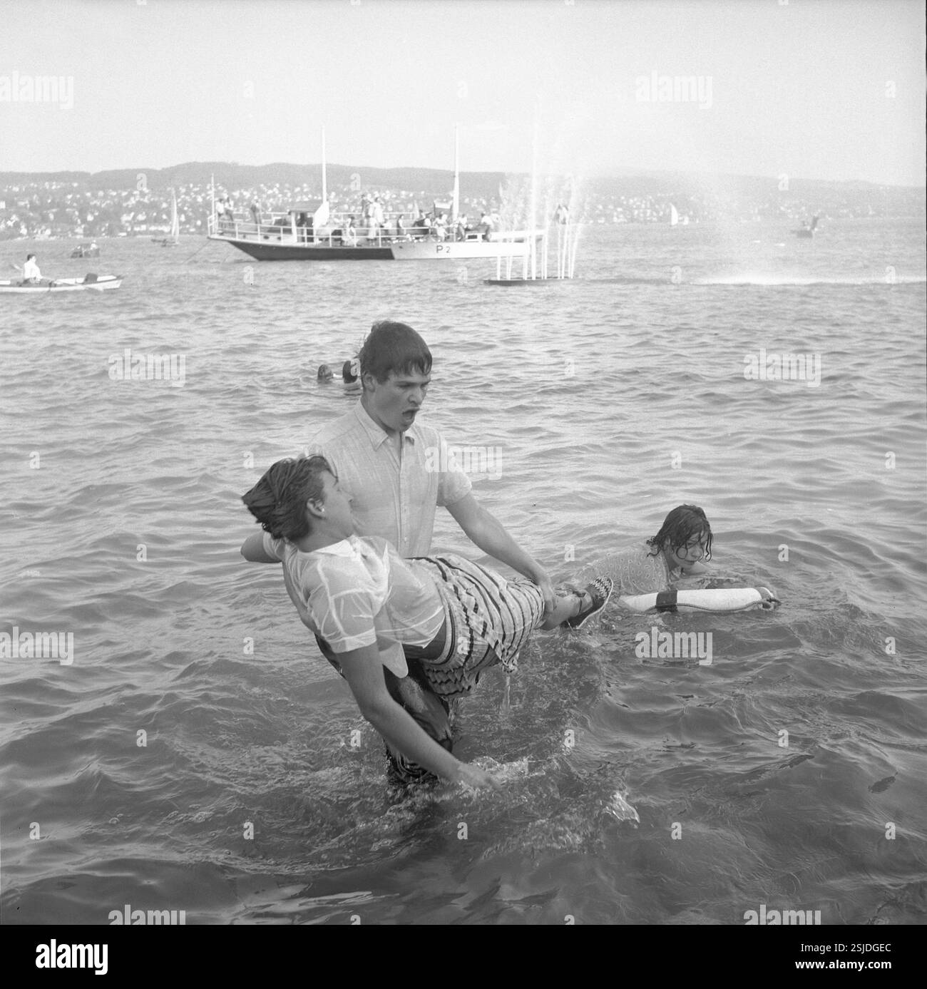 Im Rahmen einer gestellten Schiffsexplosion stürzten sich die 'passagiere' ins Wasser und wurden von Rettungsschwimmern geborgen und an Land medizinisch betreut#l'addestramento includeva una falsa esplosione di una barca sulla quale i "passeggeri" saltarono in mare e furono salvati dal bagnino. Sono stati poi curati dal medico a terra.--- Rettungsübung am 'Rotkreuztag' der SAFFA 1958#addestramento di soccorso nel 'giorno della Croce Rossa' della fiera SAFFA 1958- RDB DI DUKAS Foto Stock