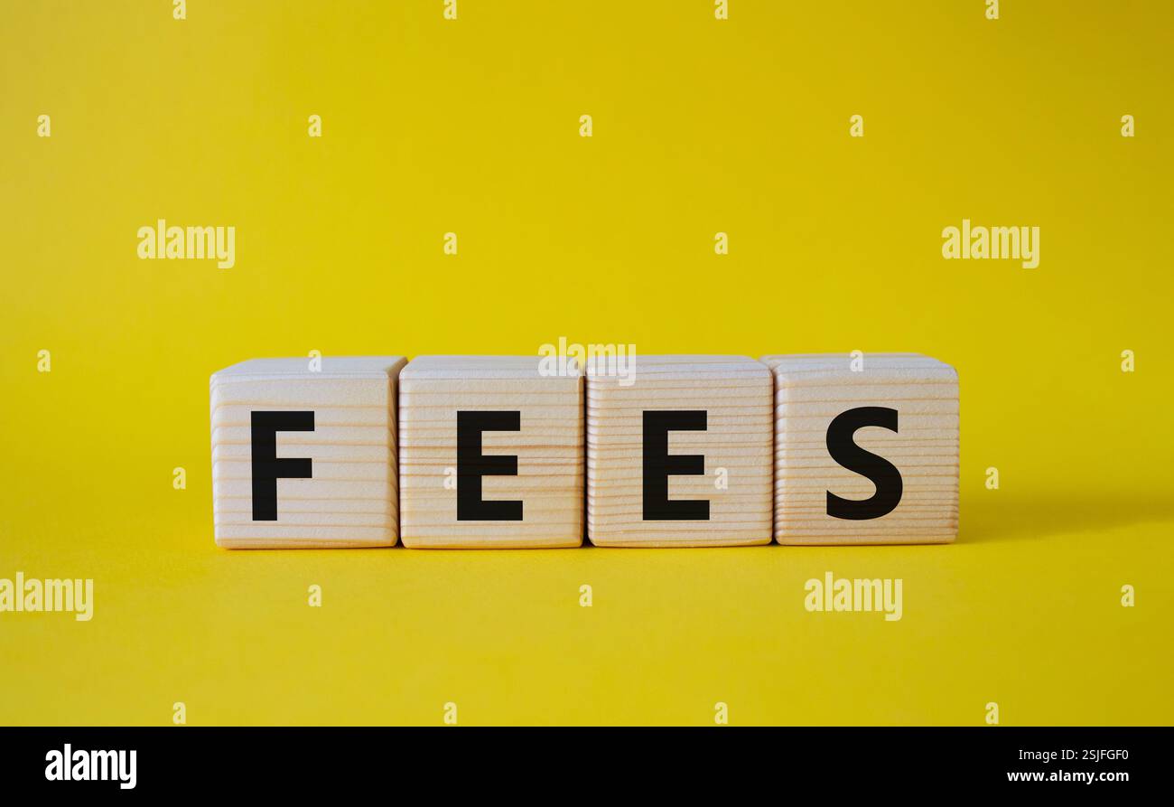 Simbolo delle tariffe. Costo della parola concettuale sui cubi di legno. Bellissimo sfondo giallo. Business e tariffe. Copia spazio. Foto Stock