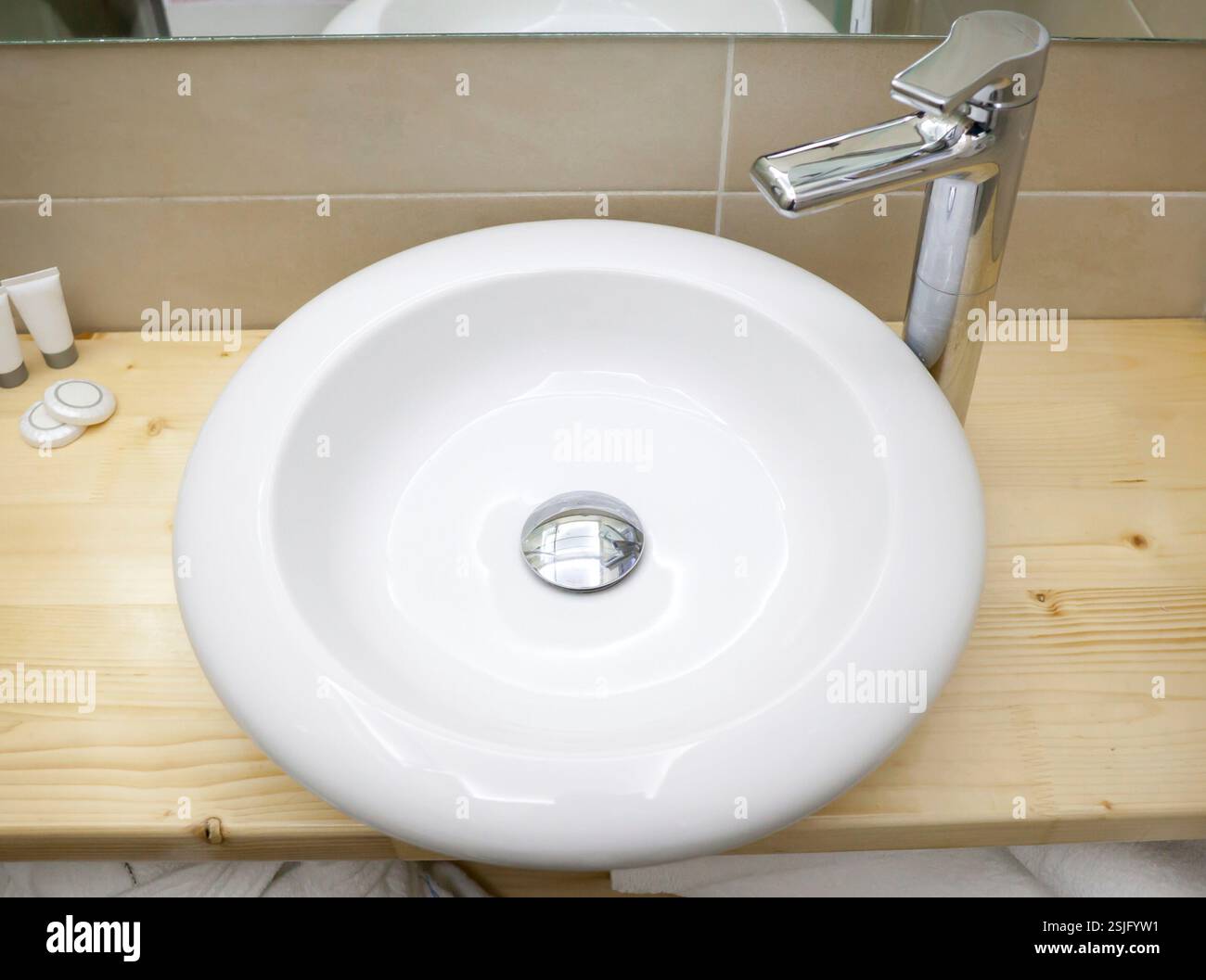 Bianco rotondo il lavandino in bagno moderno sul ripiano di legno Foto Stock