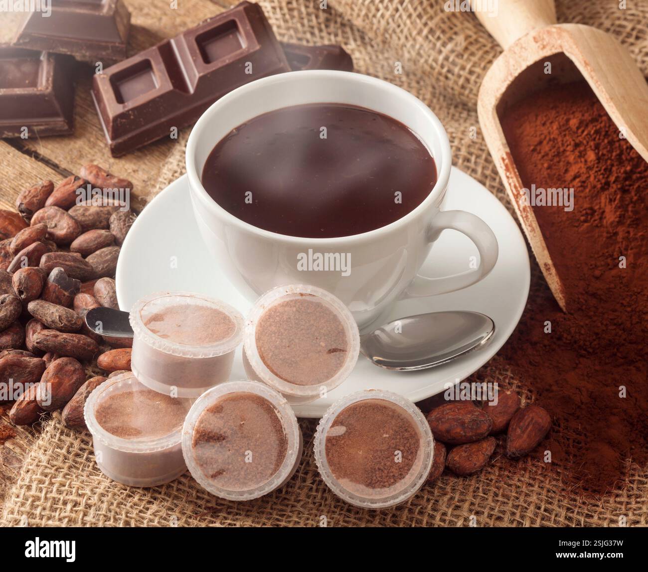 Tazza di cioccolata calda con cialde, cacao in polvere, le fave di cacao e pezzi di cioccolato. Foto Stock