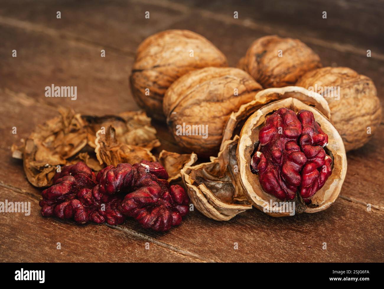 Noci rosse del Danubio su sfondo di legno. Ha avuto origine da una croce tra alberi di noce inglesi e persiani Foto Stock