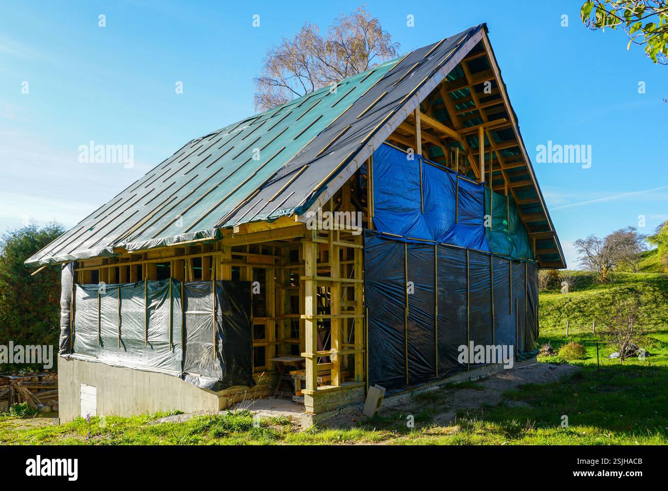 Piccola struttura in legno struttura residenziale telaio su fondamenta in calcestruzzo nel processo di costruzione in ambiente rurale Foto Stock