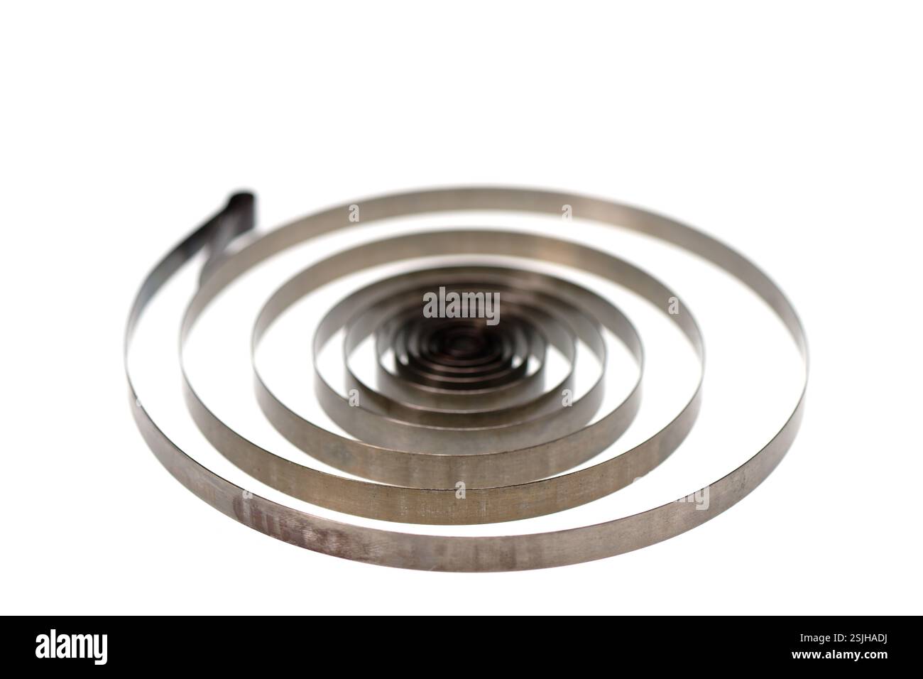 Molla a spirale in metallo isolata su sfondo bianco, messa a fuoco selettiva Foto Stock