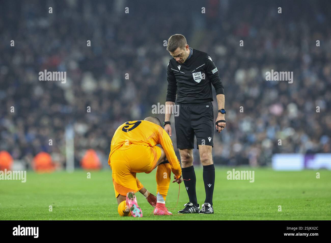 L'arbitro Clement Turpin controlla Kylian Mbappé del Real Madrid dopo che il suo pizzo cade dalla scarpa durante il Play-off di UEFA Champions League contro il Real Madrid all'Etihad Stadium, Manchester, Regno Unito, 11 febbraio 2025 (foto di Mark Cosgrove/News Images) Foto Stock