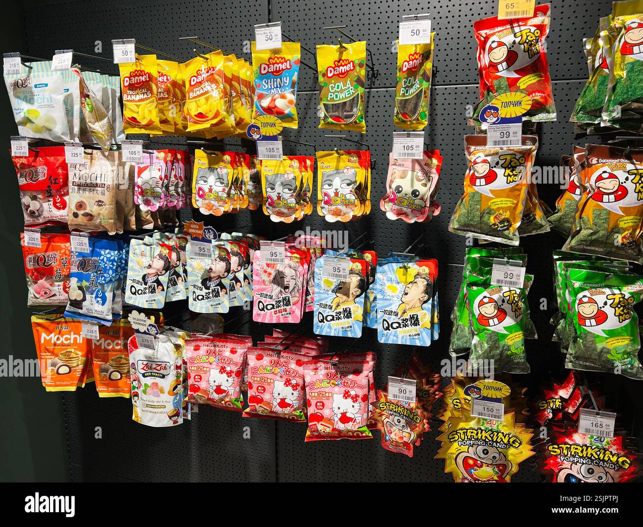 Kiev, Ucraina - 11 febbraio 2025: Ampia varietà di spuntini e caramelle in mostra con borse ed etichette Foto Stock