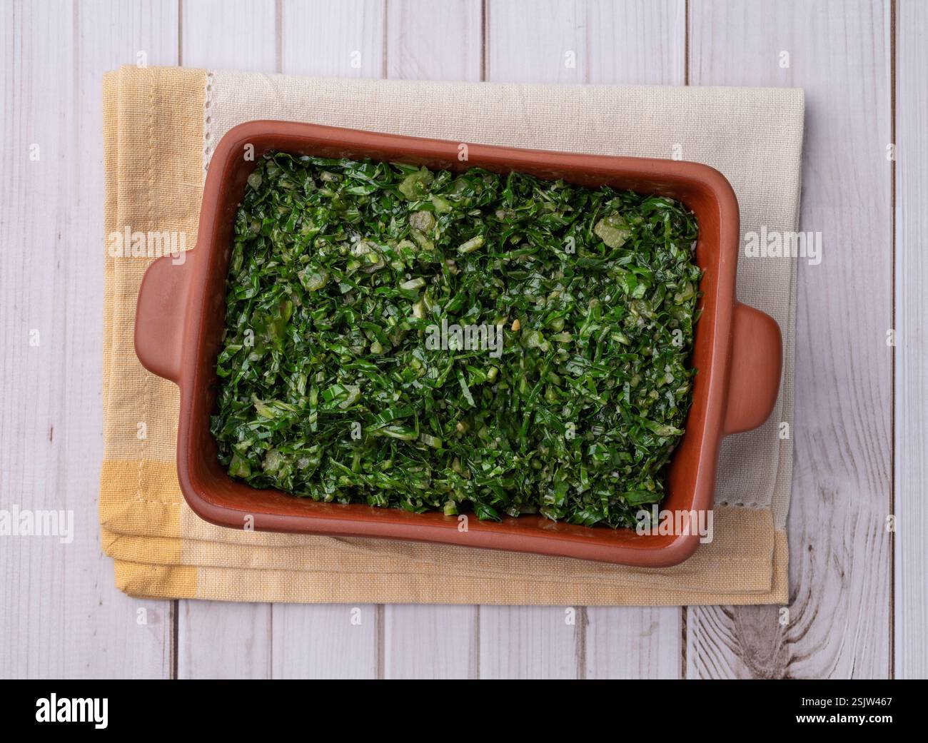 Strisce di cavolo cotte, tipico contorno di feijoada brasiliano in un piatto su un tavolo di legno. Foto Stock