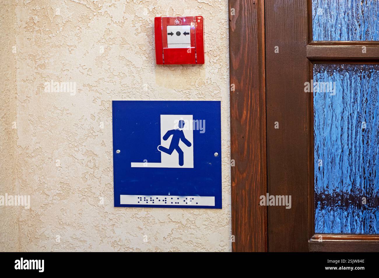 segno di un uomo che corre per la copertura su un muro giallastro all'interno Foto Stock