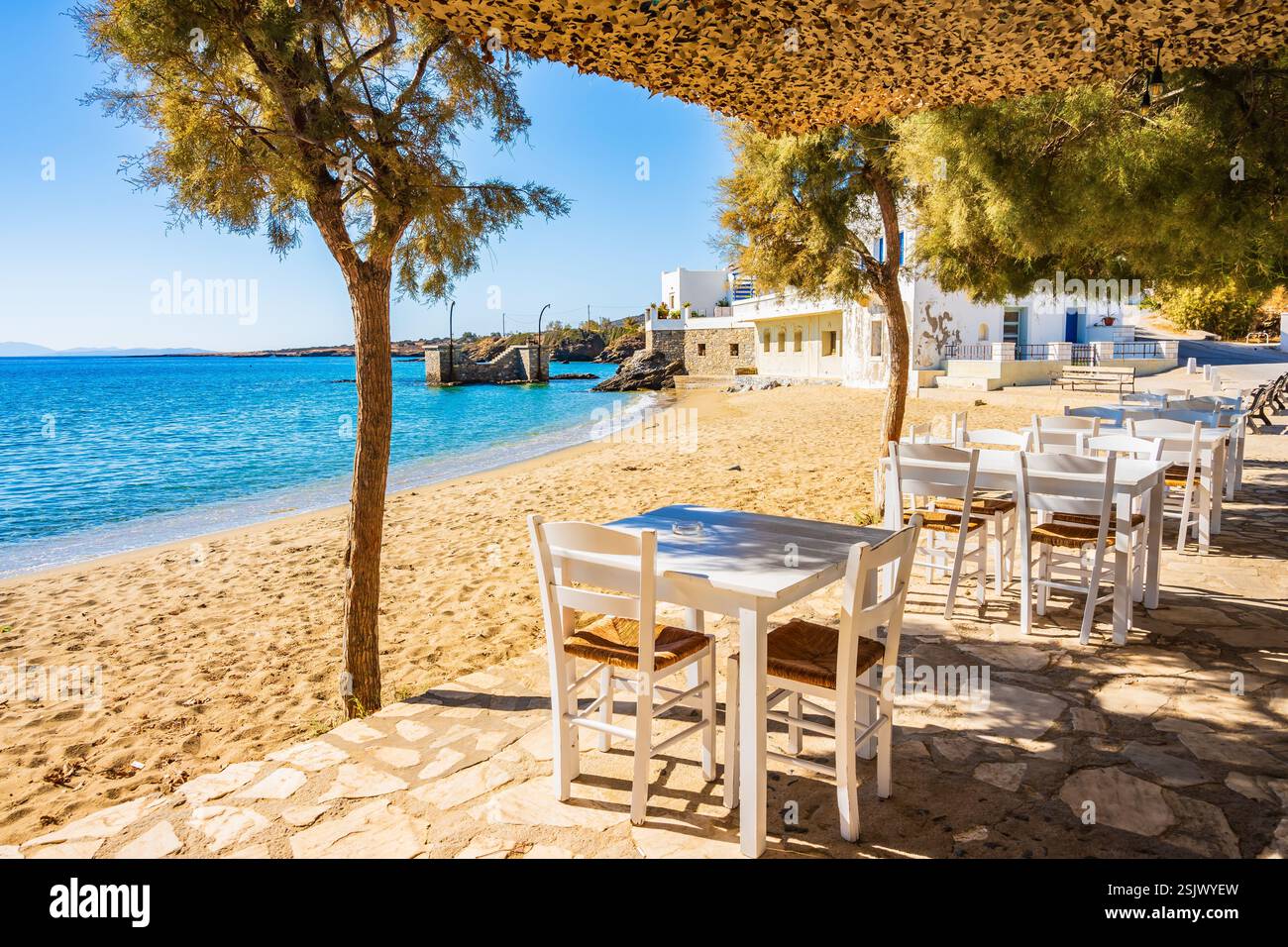 Tavoli con sedie nel ristorante greco taverna sulla spiaggia nel villaggio di Motsouna, isola di Naxos, Cicladi, Grecia Foto Stock