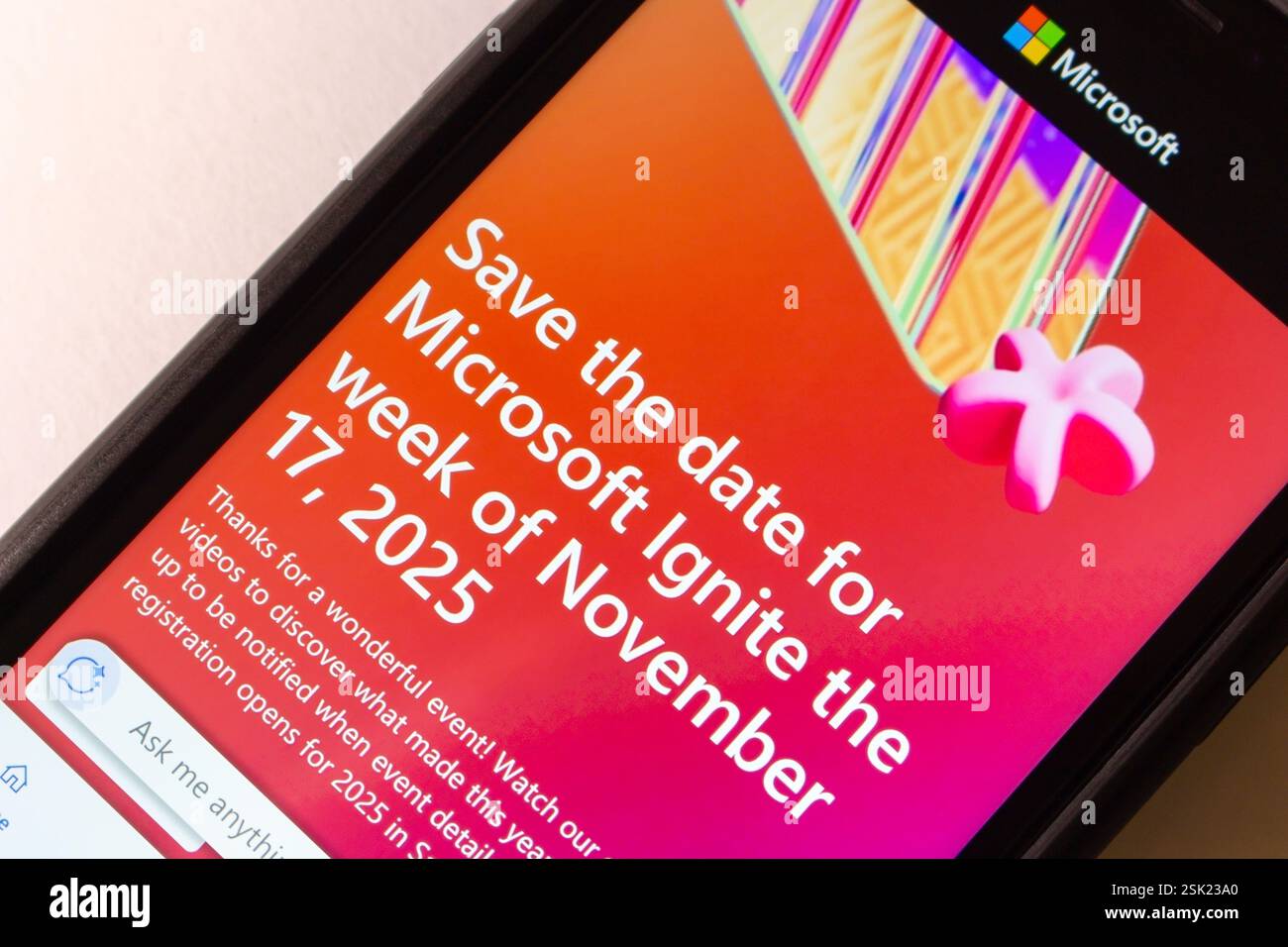 Primo piano dello schermo di uno smartphone che visualizza l'annuncio dell'evento Microsoft Ignite 2025, evidenziando la data e il design promozionale Foto Stock