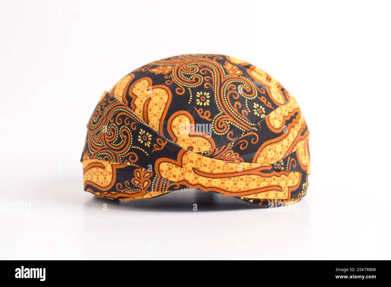Blangkon, una tradizionale copertura giavanese per la testa da uomo realizzata in tessuto batik, isolata su uno sfondo bianco. Foto Stock