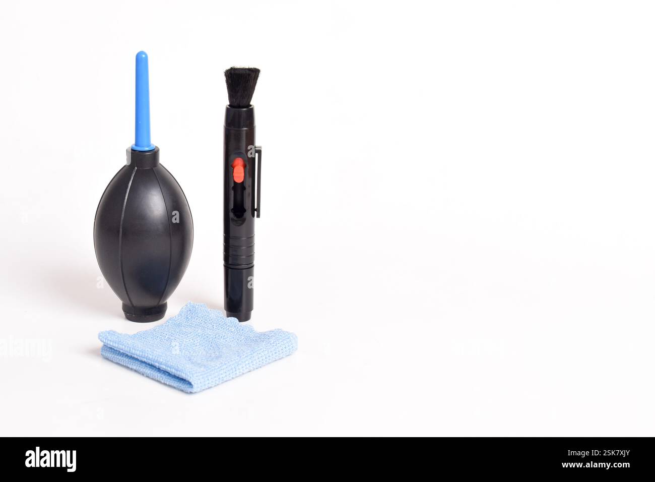 Set di pulizia per la fotocamera. Soffiatore d'aria, panno in microfibra, spazzola. Isolato su sfondo bianco Foto Stock