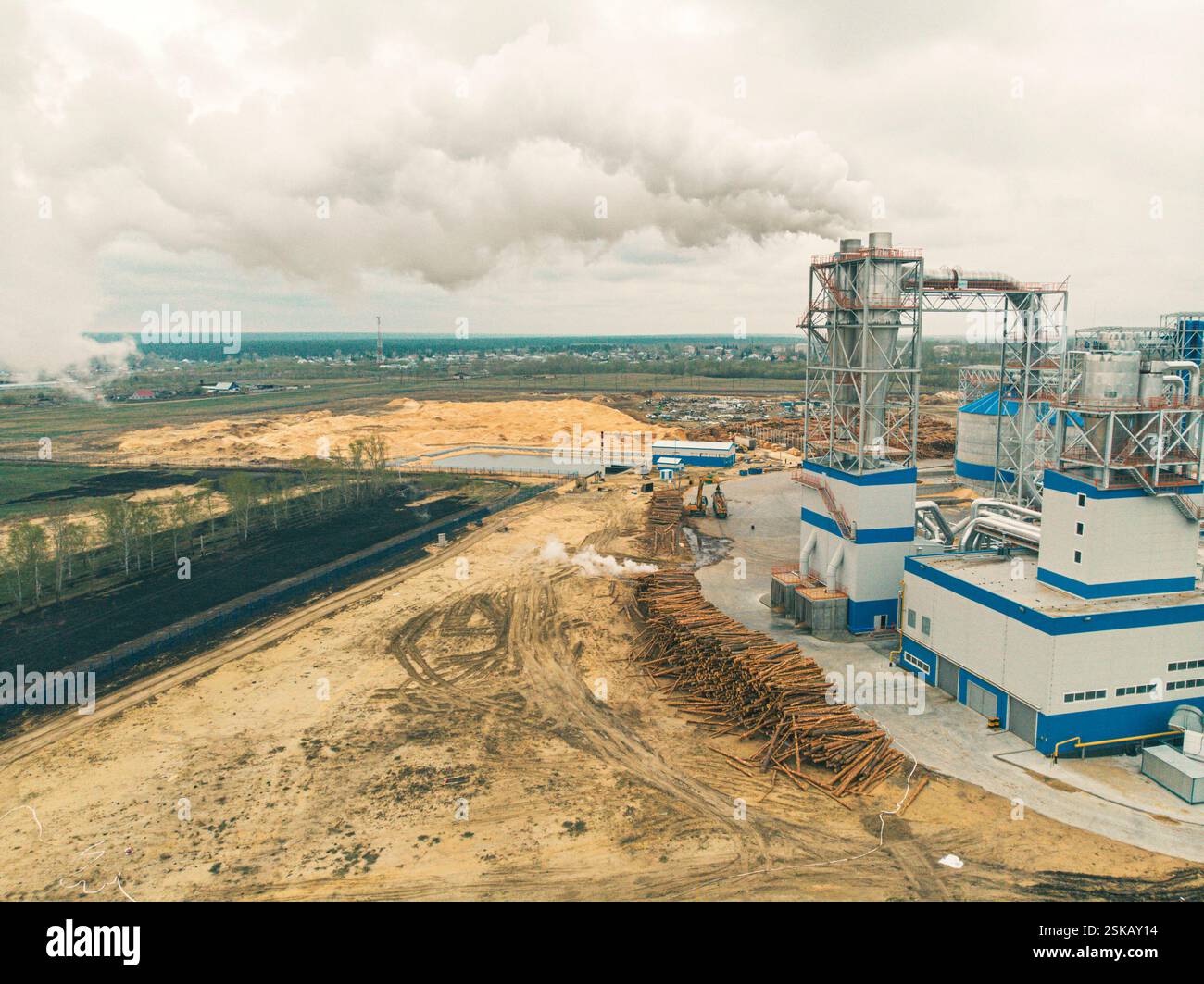 Fumo bianco nel cielo blu, il problema dell'ecologia. Fumo da un camino in un impianto di lavorazione del legno Foto Stock