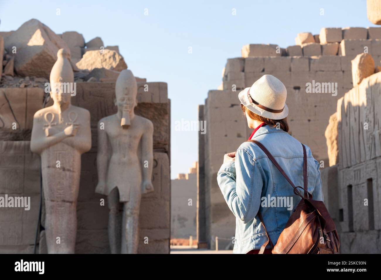 Una ragazza che guarda le rovine del grandioso tempio di Karnak nell'antica città di Luxor in Egitto Foto Stock