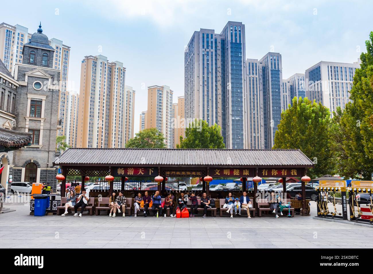 Persone sedute su panchine all'ingresso dell'antica strada culturale di Tianjin, Cina Foto Stock