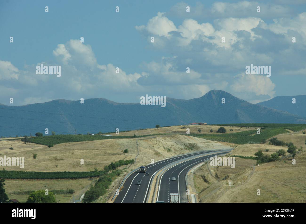 Autostrada. Veicoli che guidano su un'autostrada a più corsie circondata da colline ondulate e montagne BULGARIA con un cielo nuvoloso. Paesaggio DELLA BULGARIA. La foto Foto Stock