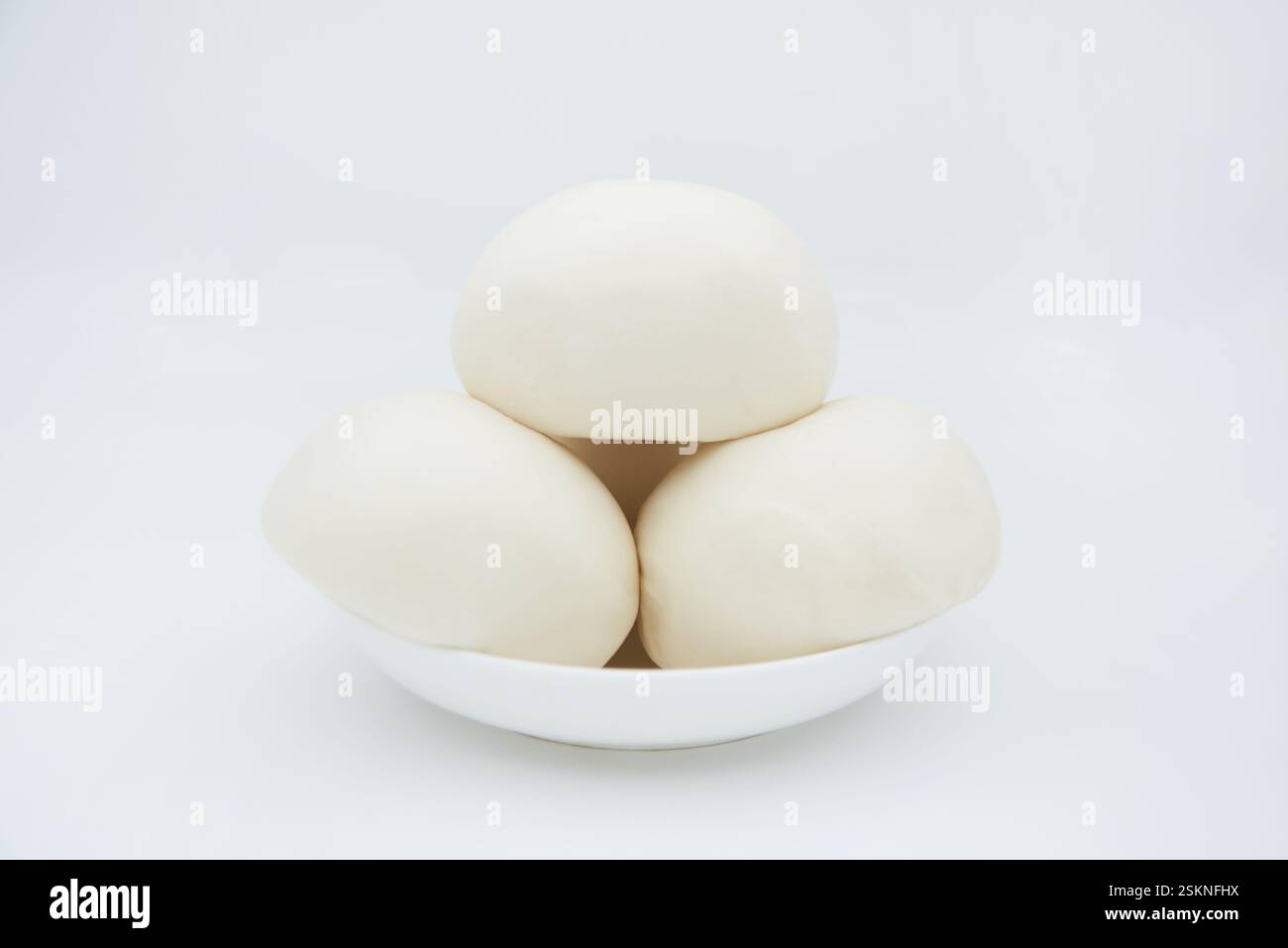 I panini bianchi e soffici sono impilati su un piccolo piatto bianco Foto Stock