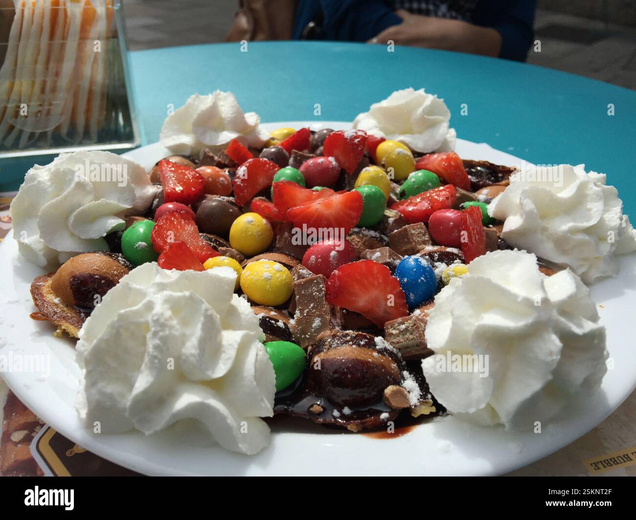 Waffle dorati, Braga, Portogallo. Ricoperto di fragole, caramelle al cioccolato, panna montata, salsa al cioccolato. Delizia decadente. Soddisfa le esigenze dei clienti Foto Stock