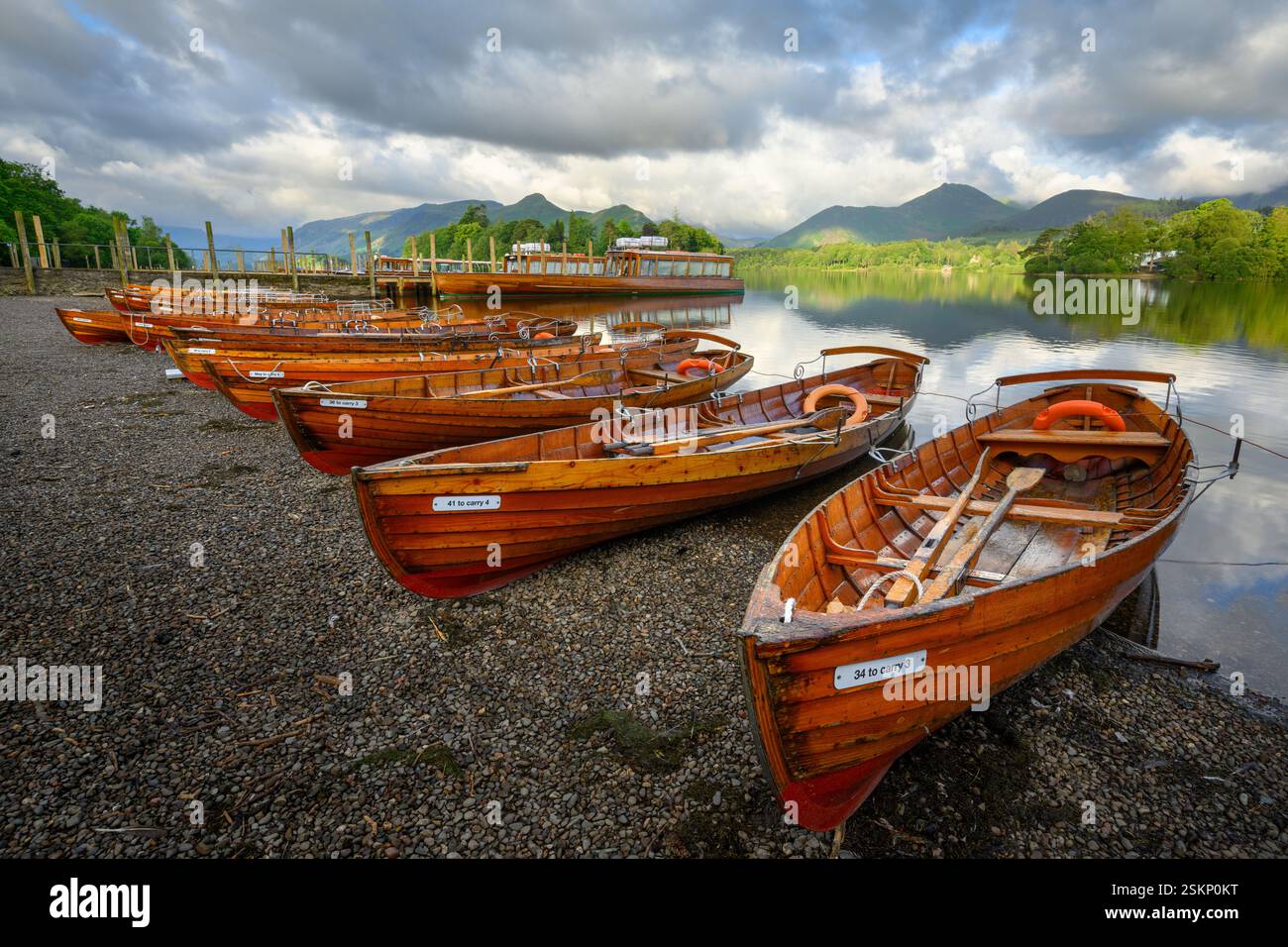 Barche a remi in legno sul litorale di Derwentwater in una mattinata d'estate. Keswick, Lake District, Regno Unito. Foto Stock