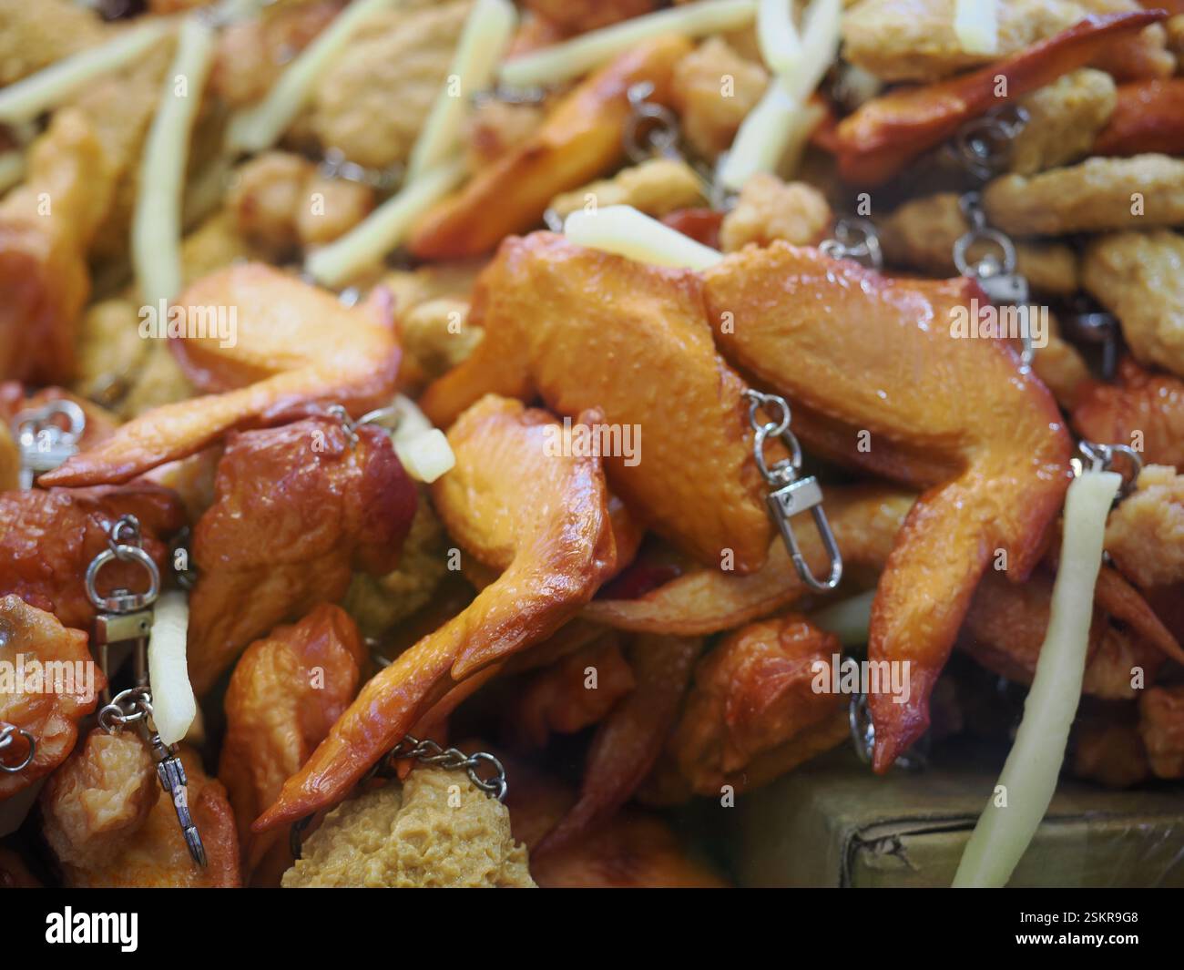 Immagine di una macchina per l'artiglio contenente repliche in plastica di patatine fritte e ali di pollo. Foto Stock