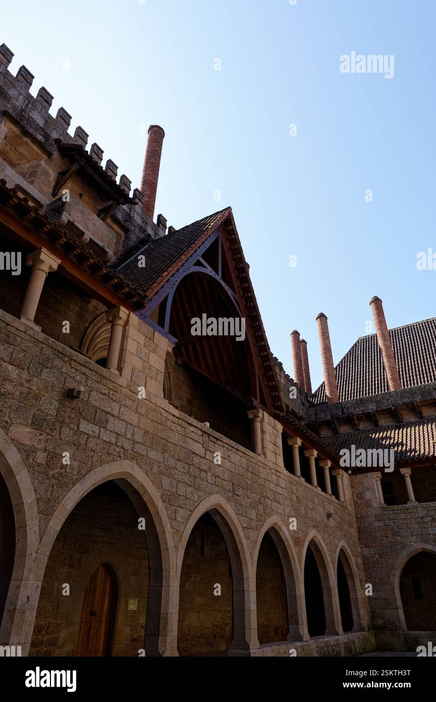 La luce del sole getta ombre sugli archi del Palazzo dei Duchi di Braganza a Guimarães Foto Stock