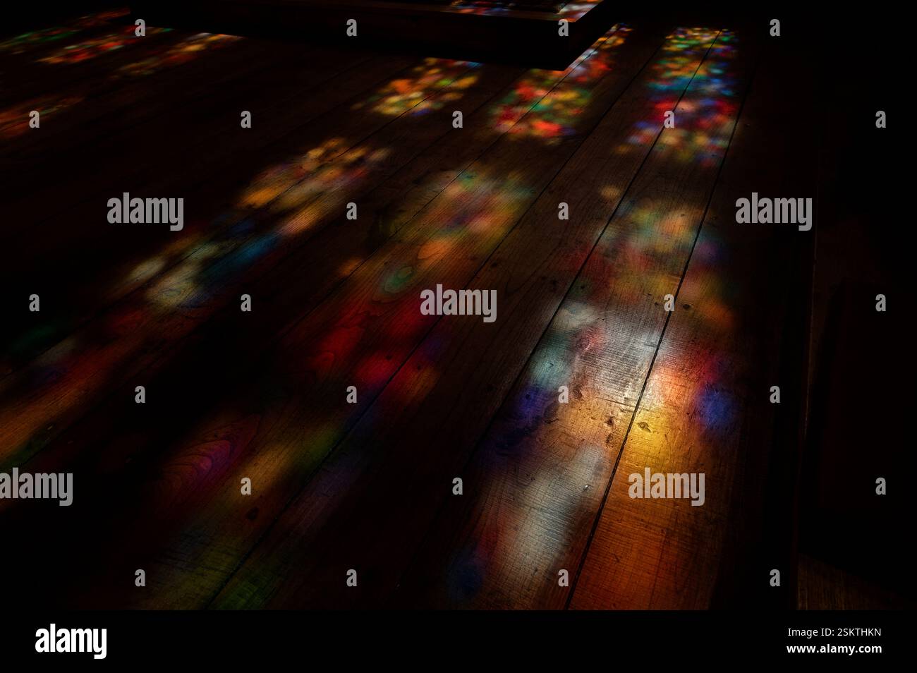 Luci soffuse e colorate danzano sui pavimenti in legno all'interno del Palazzo dei Duchi di Braganza Foto Stock