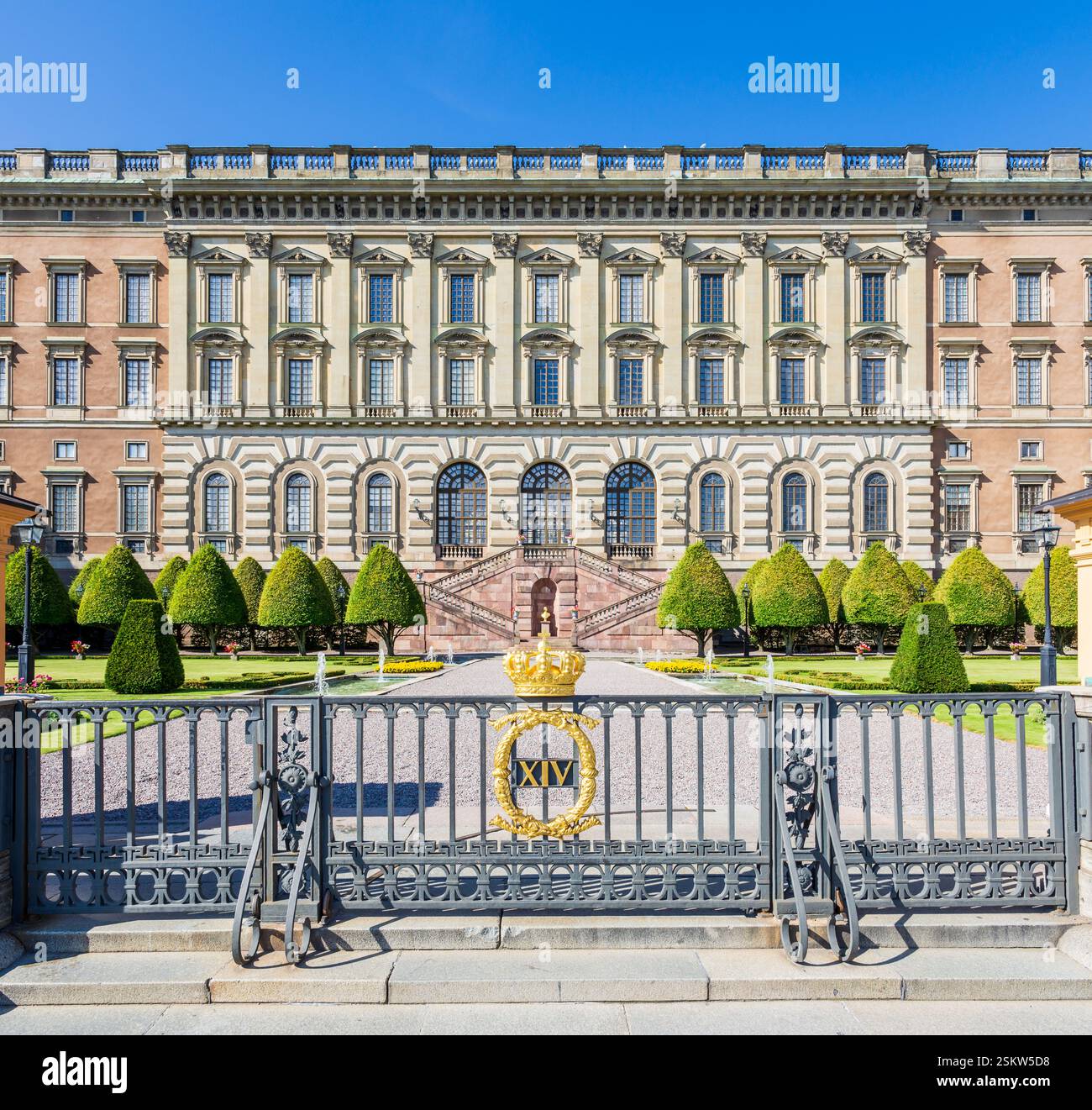 Facciata orientale del Palazzo reale di Stoccolma, Svezia, con il Logården sottostante e una corona dorata sopra il monogramma di Carlo XIV Giovanni sulla recinzione. Foto Stock