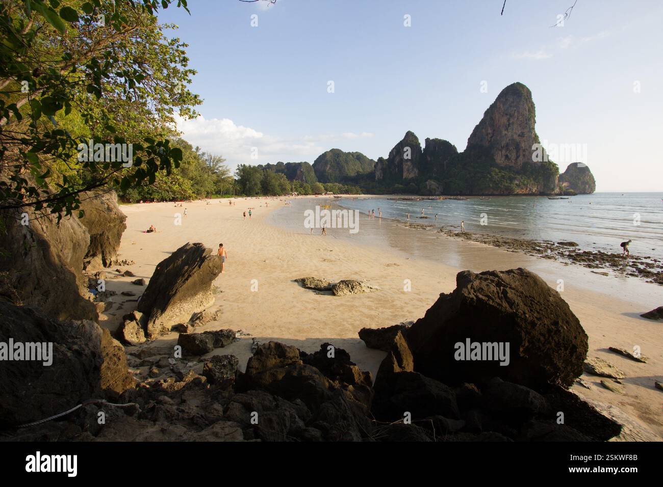 Una vista di Railay Beach, Thailandia, caratterizzata da sabbia dorata, acque cristalline e spettacolari scogliere calcaree circondate da una vegetazione lussureggiante. Foto Stock