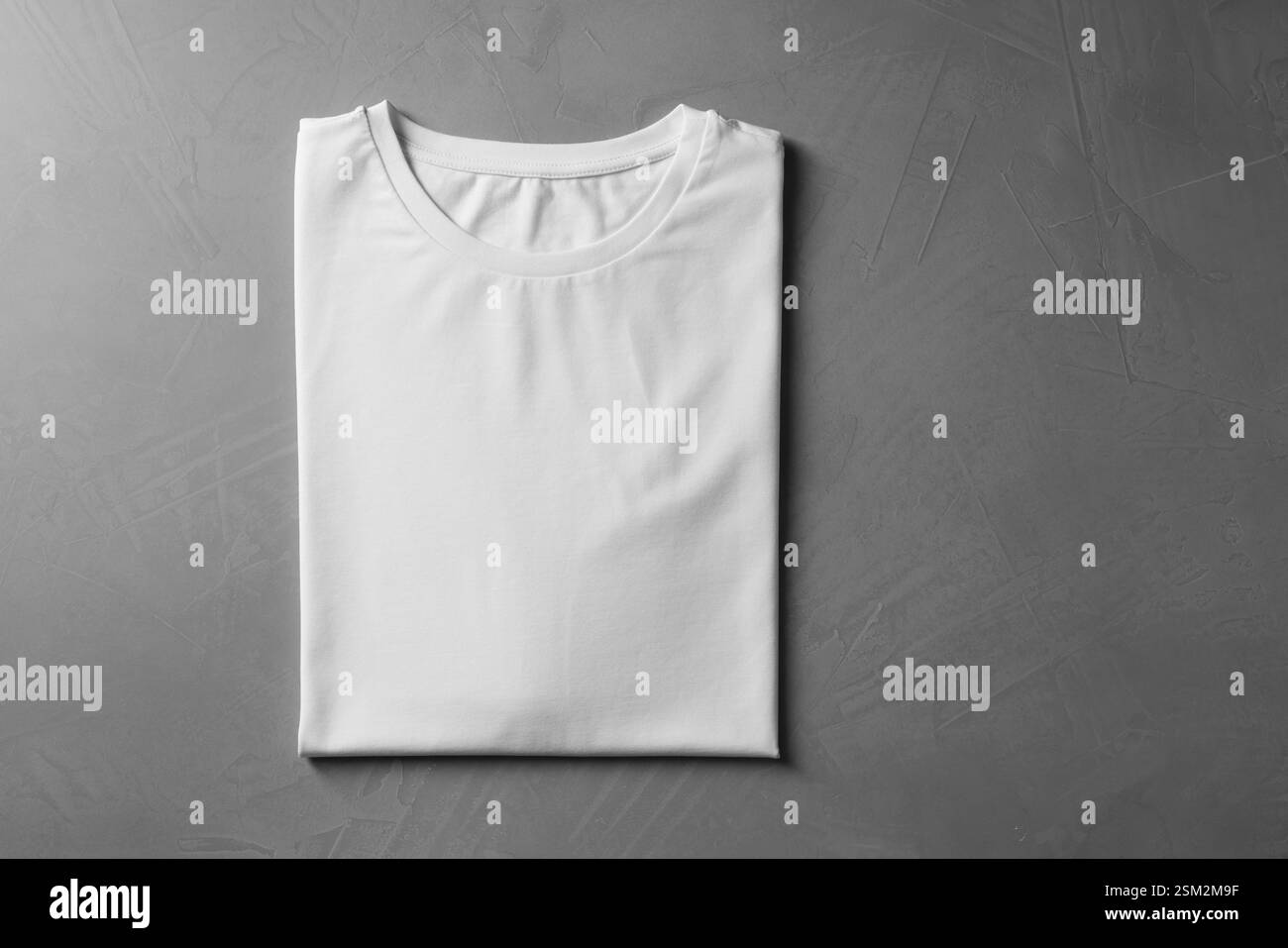 T-shirt bianca vuota su sfondo grigio, vista dall'alto. Mockup per il design Foto Stock