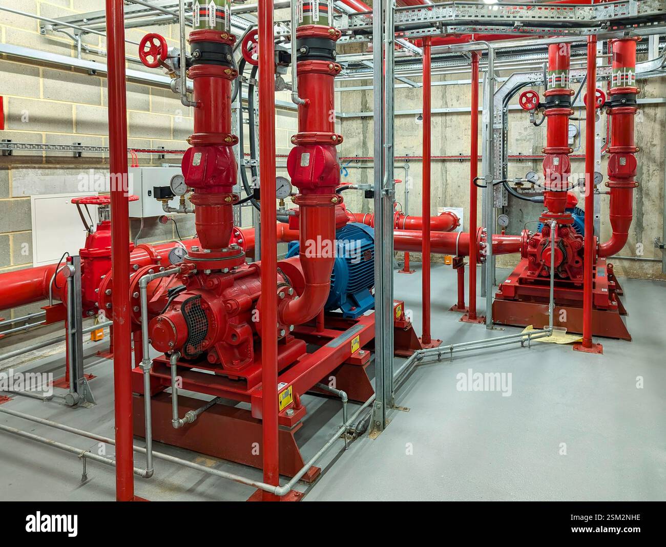 Sala pompe antincendio industriale dotata di pompe antincendio multiple e motori elettrici. Foto Stock