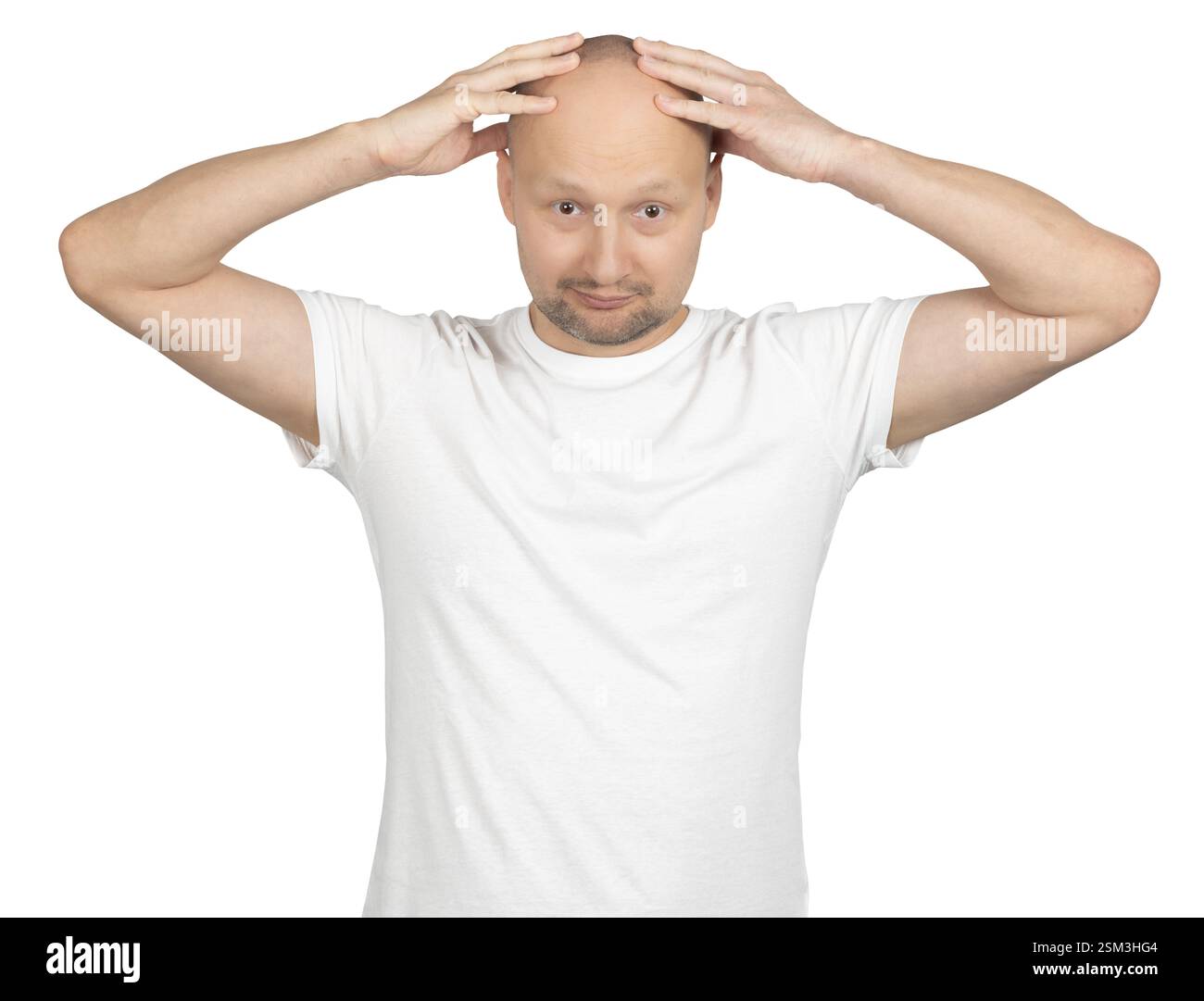 Un uomo caucasico calvo con la barba corta indossa una t-shirt bianca e mette entrambe le mani sulla testa con un'espressione sorpresa. Foto Stock